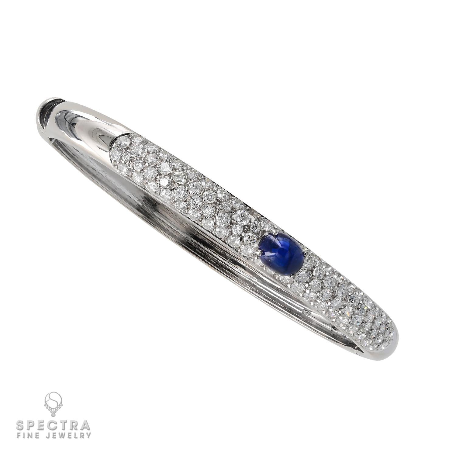 Crafted in 18K white gold, this Contemporary Oval Sapphire Diamond Pavé Bangle Bracelet dazzles with a 1.49-carat cabochon sapphire embraced by sparkling diamonds weighing 2.40 carats in total. The diamonds are mostly with G-H color, VS-SI clarity.