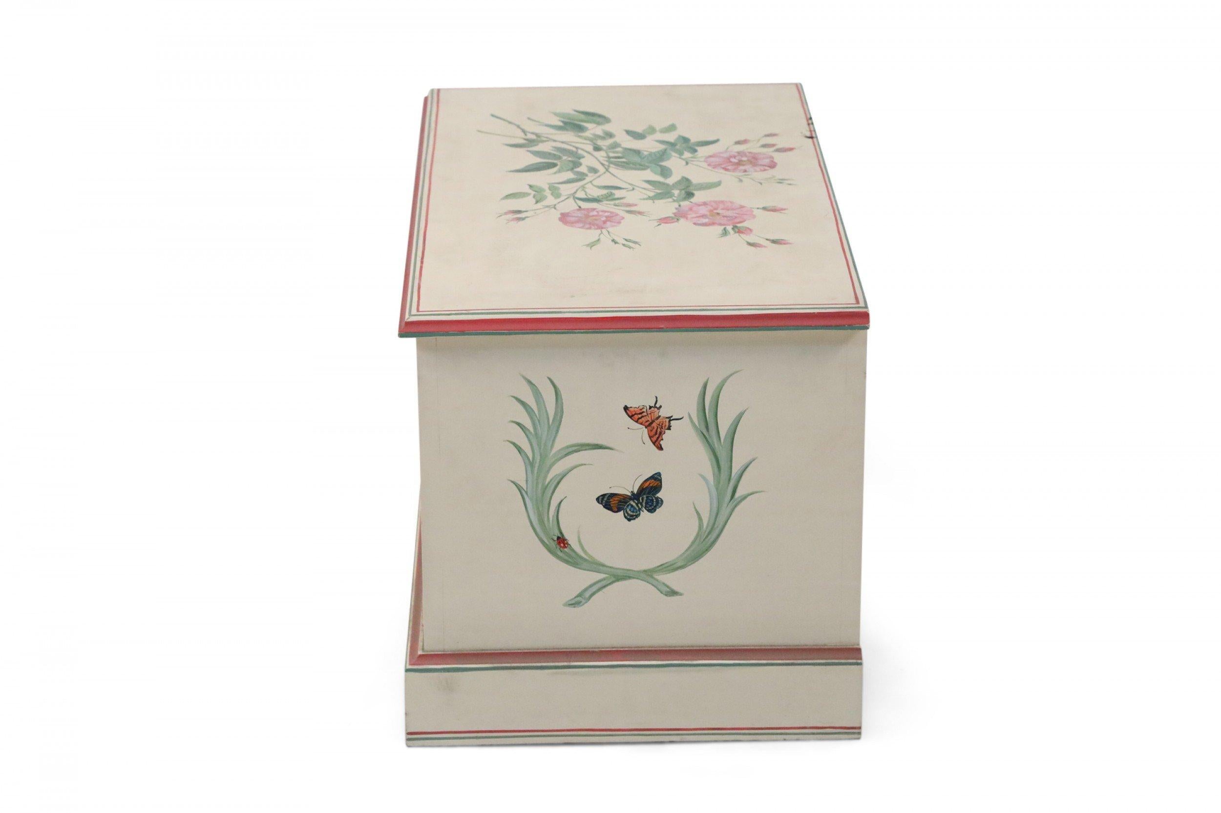 Contemporary beige painted wooden floor trunk painted with red and green trim, and decorations of florals, laurels, butterflies and ladybugs on the top, front and sides, along with the name 