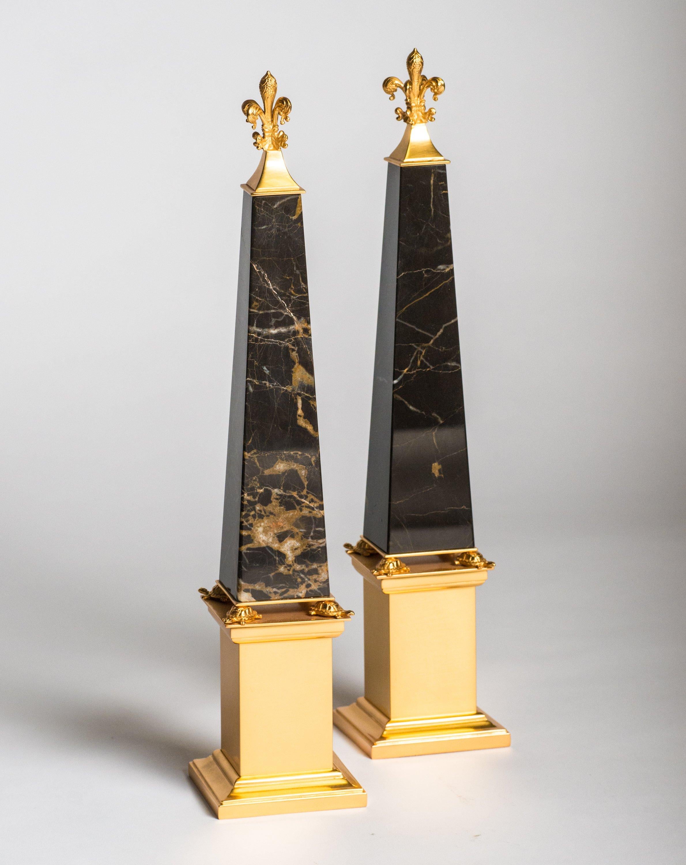 A pair of bronze & black and gold St. Laurent marble obelisks embellished with tortoises made by a master bronze maker in Florence, Italy.