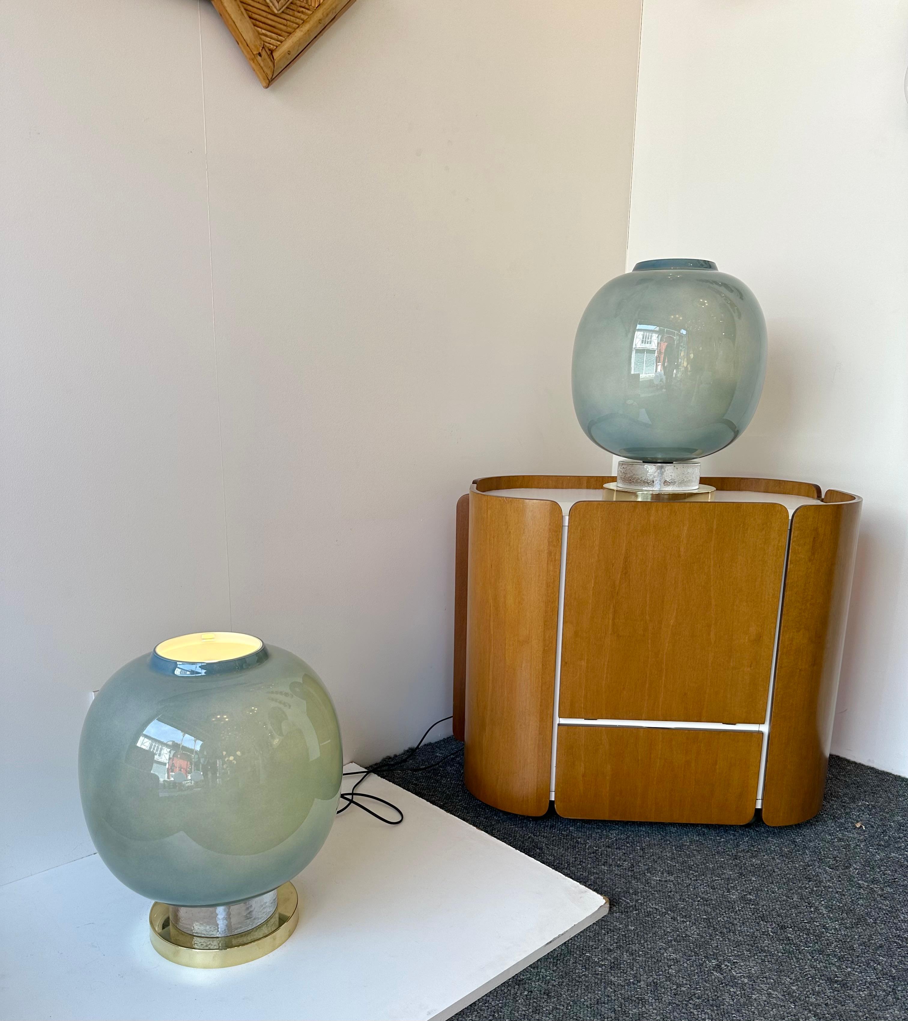 Coppia di lampade da tavolo o da comodino in ottone e vetro di Murano blu. Opera contemporanea proveniente da un piccolo laboratorio artigianale di design italiano, piccole imperfezioni dovute alla lavorazione artigianale. in un mood Mid-Century