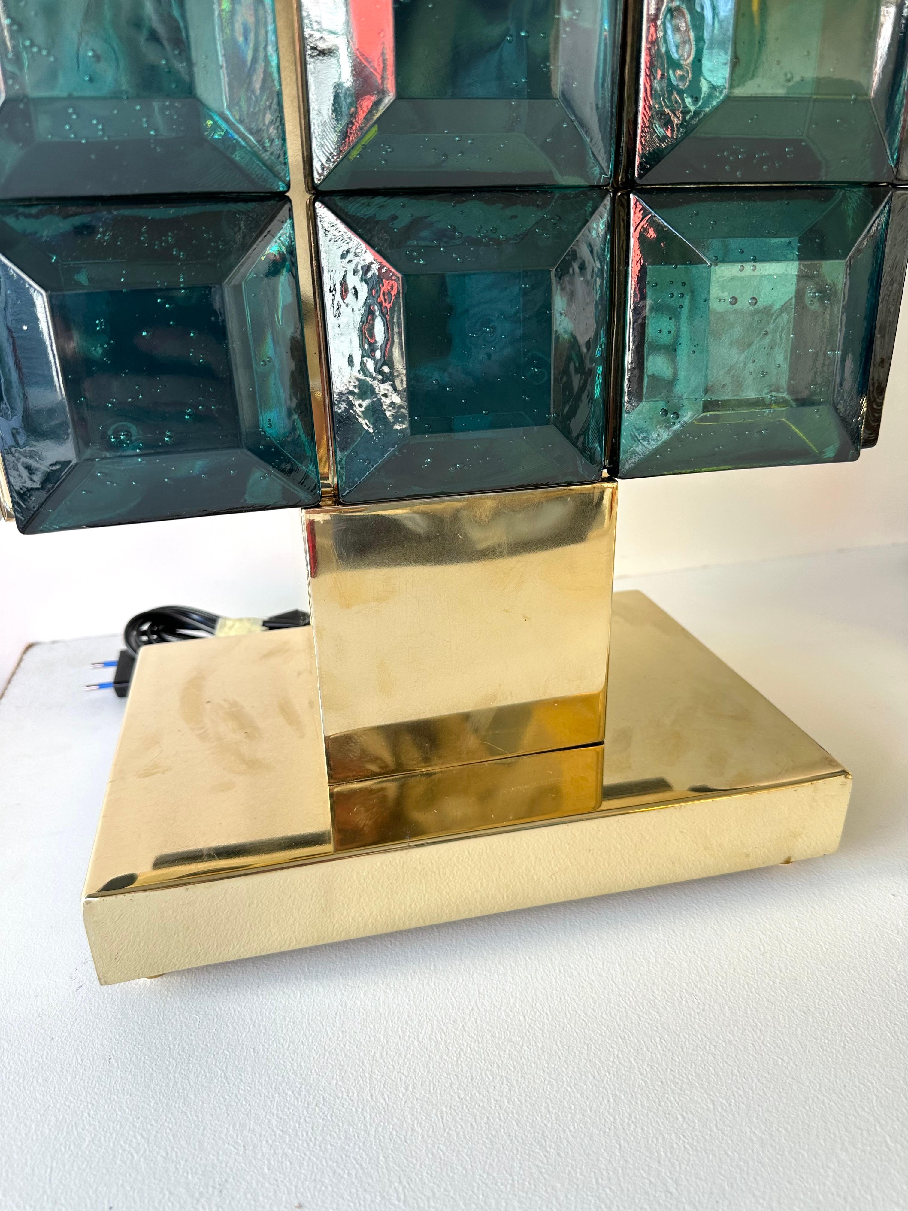 Pair of table or bedside brass lamps and petrol blue green Murano glass diamonds. Contemporary work from a small italian artisanal workshop, minor imperfections due to artisanal handmade. in a Mid-Century Modern Space Age Hollywood Regency