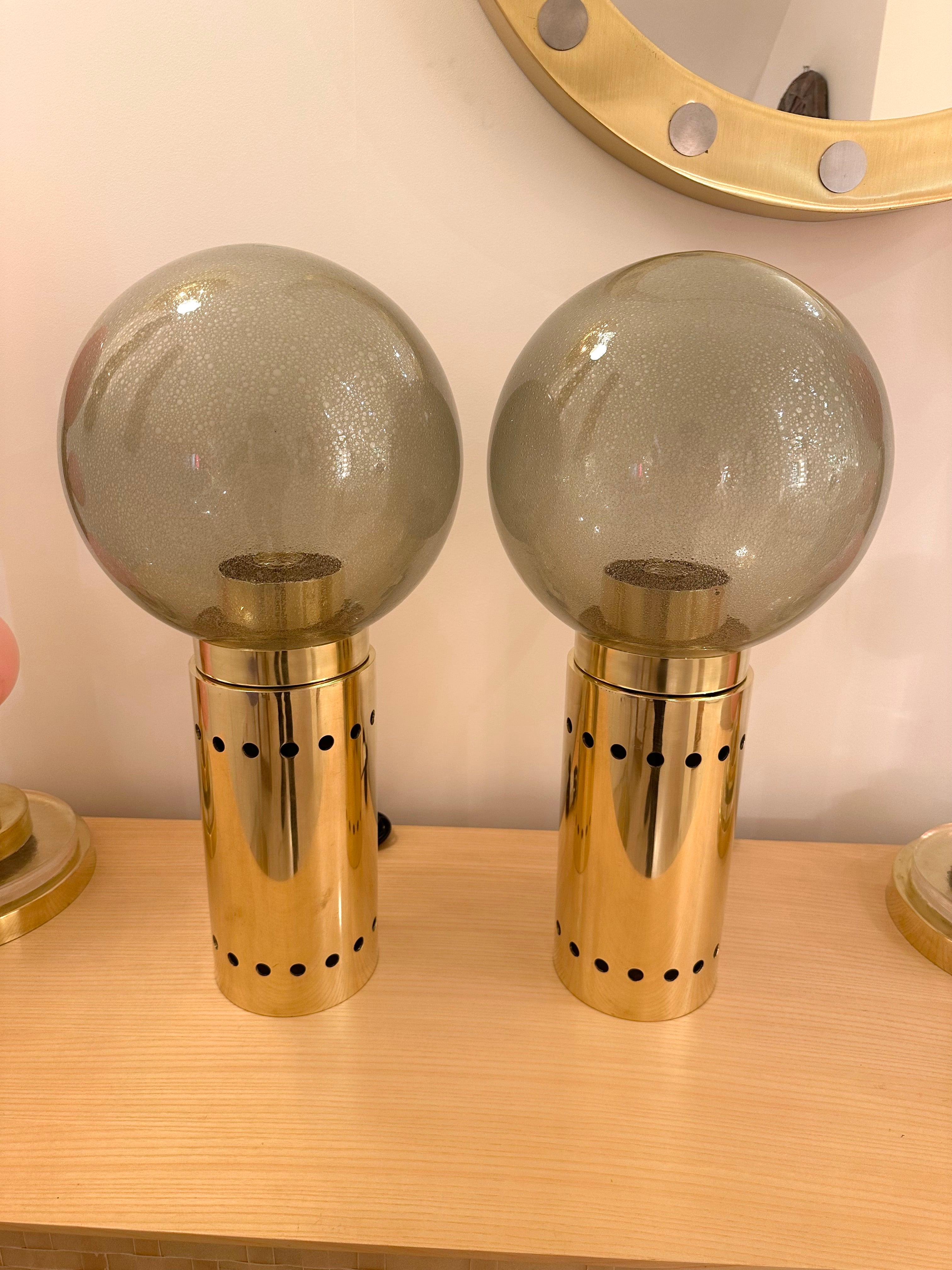 Pair of table or bedside brass lamps and gray Murano glass bubble globe. Illuminated brass base with two intern sockets. Contemporary work from a small italian artisanal workshop in a Mid-Century Modern Space Age Hollywood Regency mood.

