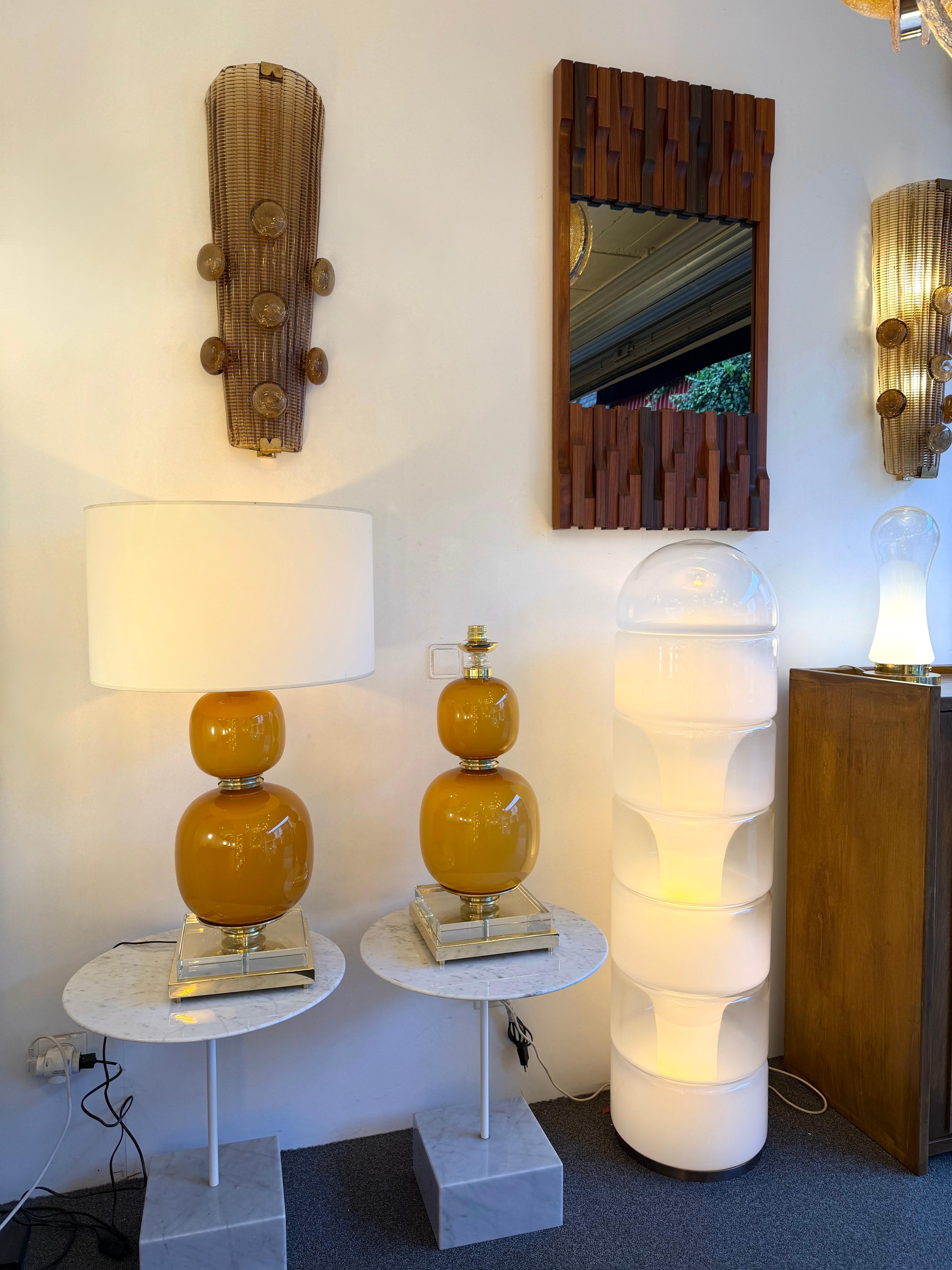 Pareja de lámparas de mesa o mesilla de noche de latón y cristal de Murano naranja. Obra contemporánea de un pequeño taller artesanal de diseño italiano, pequeñas imperfecciones debidas a la fabricación a mano artesanal. en un ambiente de Modernidad