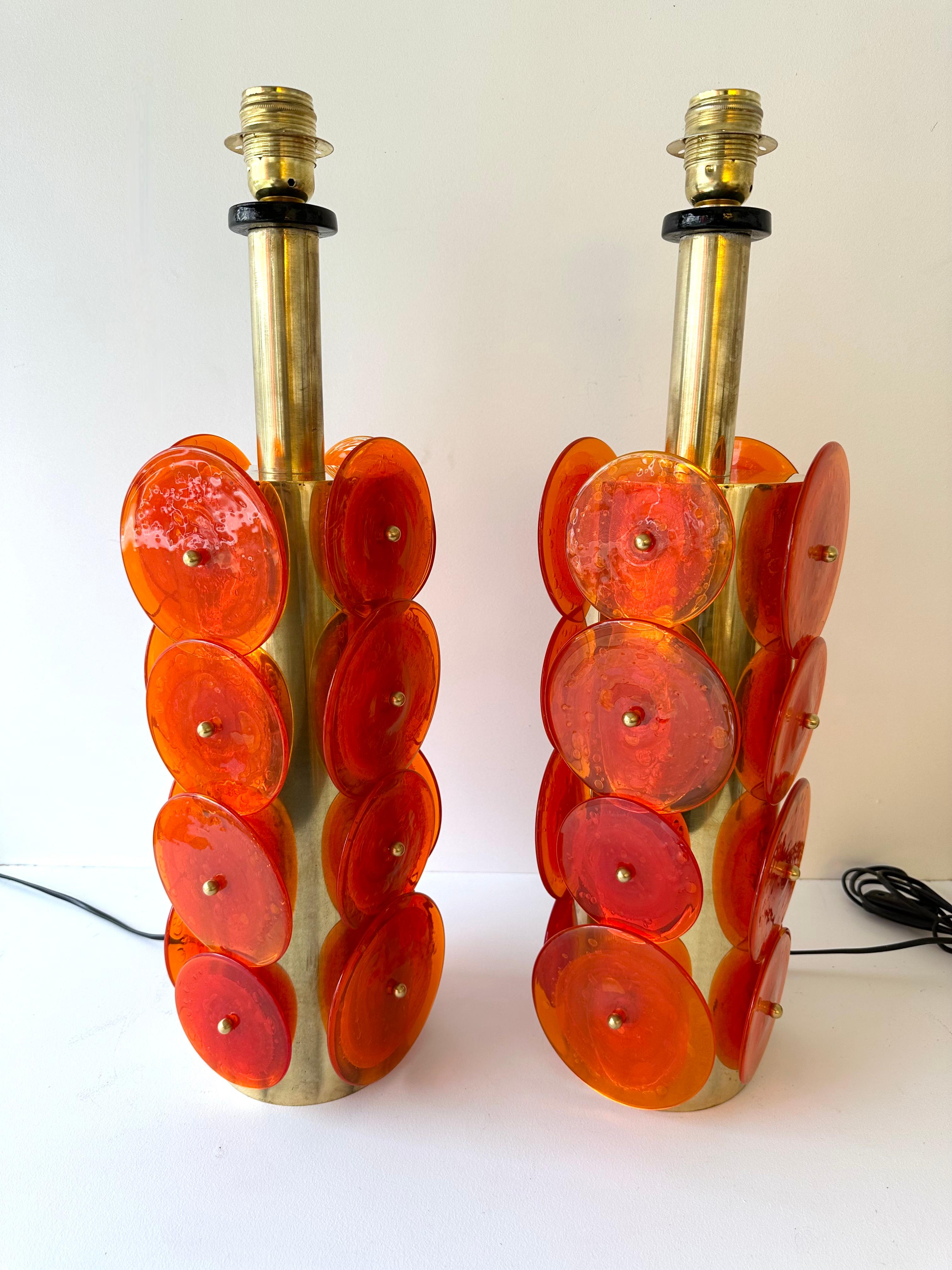 Pair of table or bedside brass lamps Murano glass orange disc. Contemporary work from a small italian artisanal design workshop, minor imperfections due to handmade, in a Mid-Century Modern Space Age Hollywood Regency mood.

Demo shades non