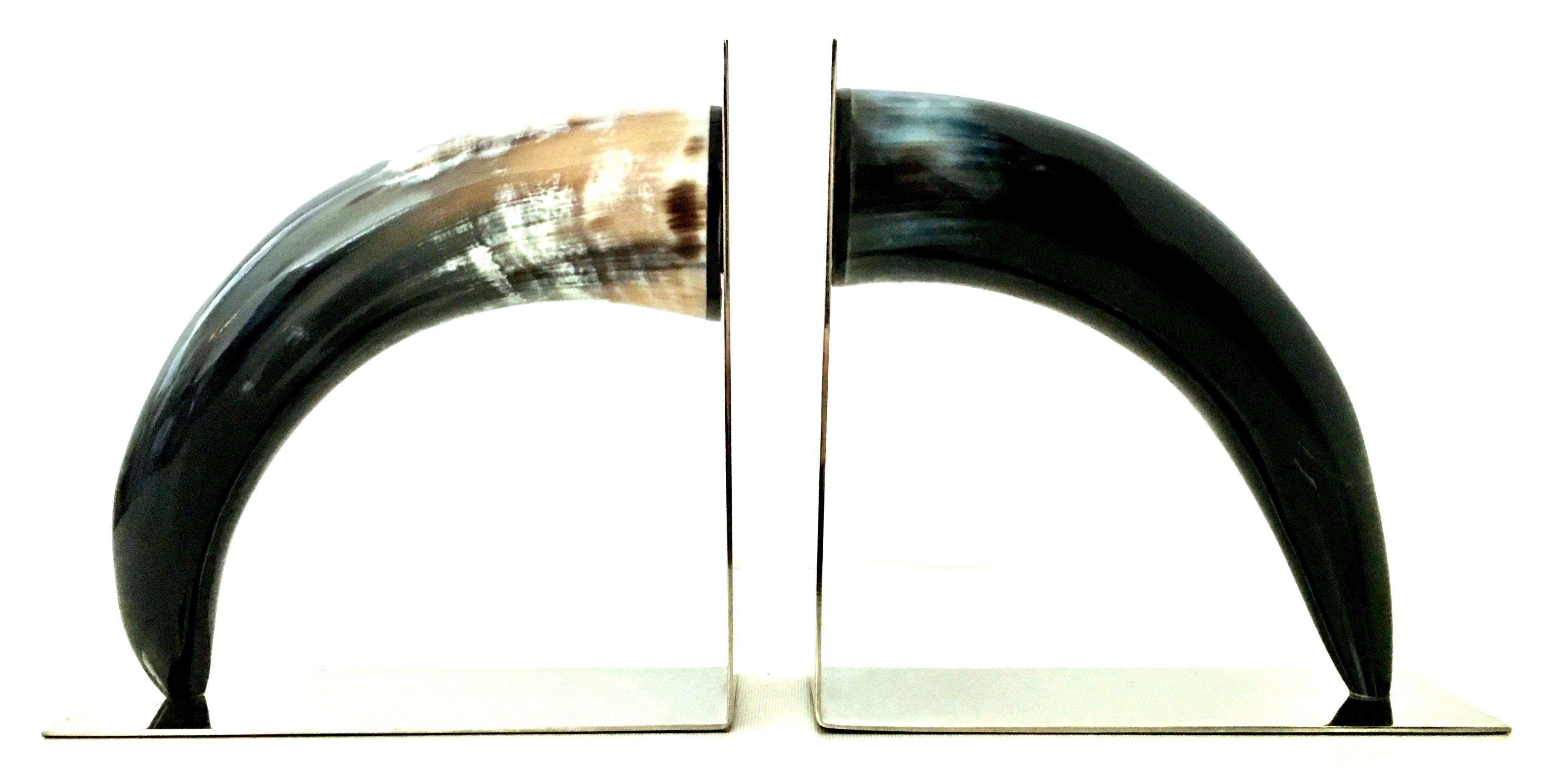 21st Century Pair of Contemporary and sleek polished black natural horn and chrome bookend sculptures. These timeless sculptural horn bookends feature polished black and tan polished buffalo horn mounted on sleek polished chrome book ends.
Each horn