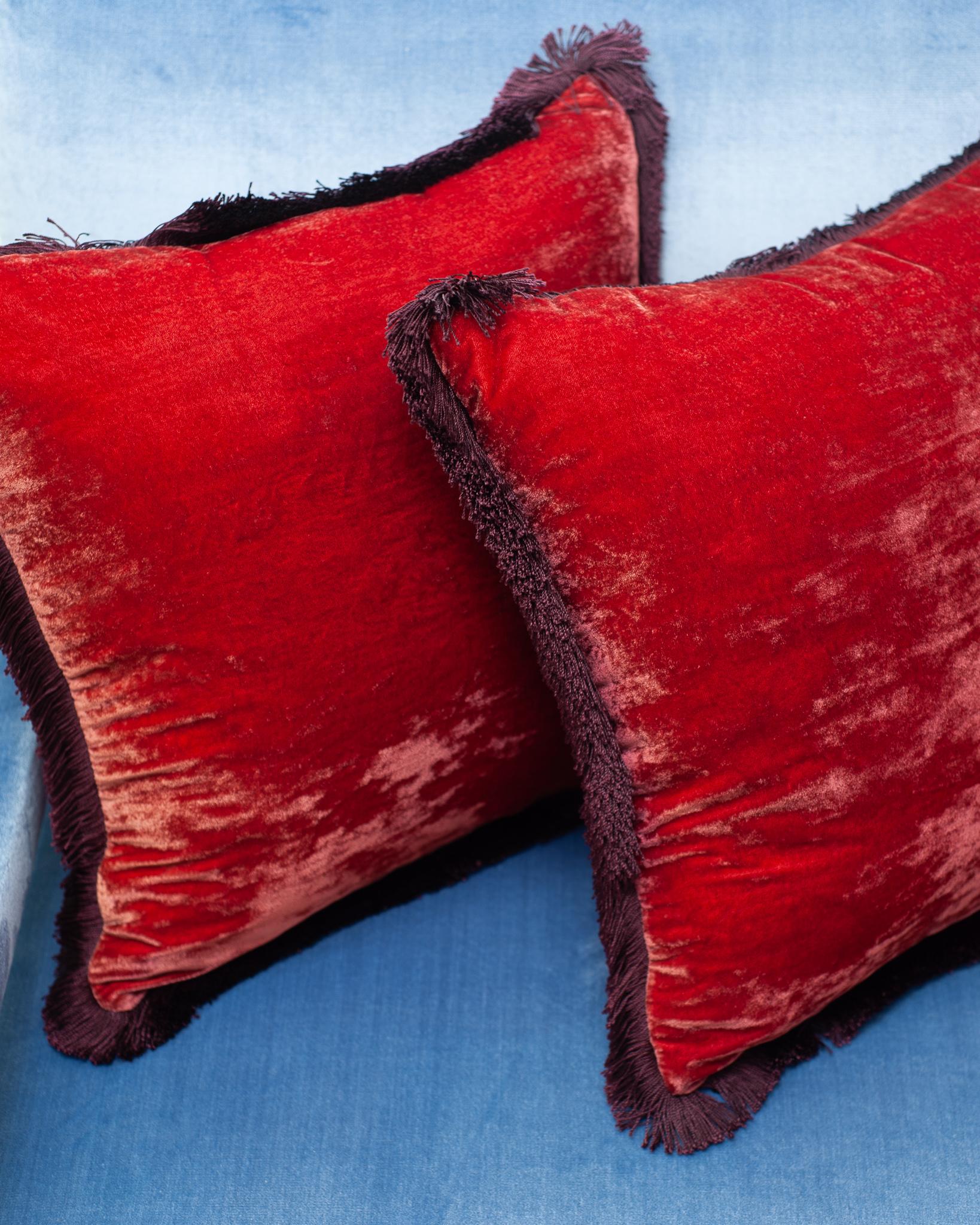 A pair of dark red rose silk velvet cushions from Anke Dreschel featuring fringe border, square shape and concealed rear zip fastening. Filled with 100% Canadian feather and down.