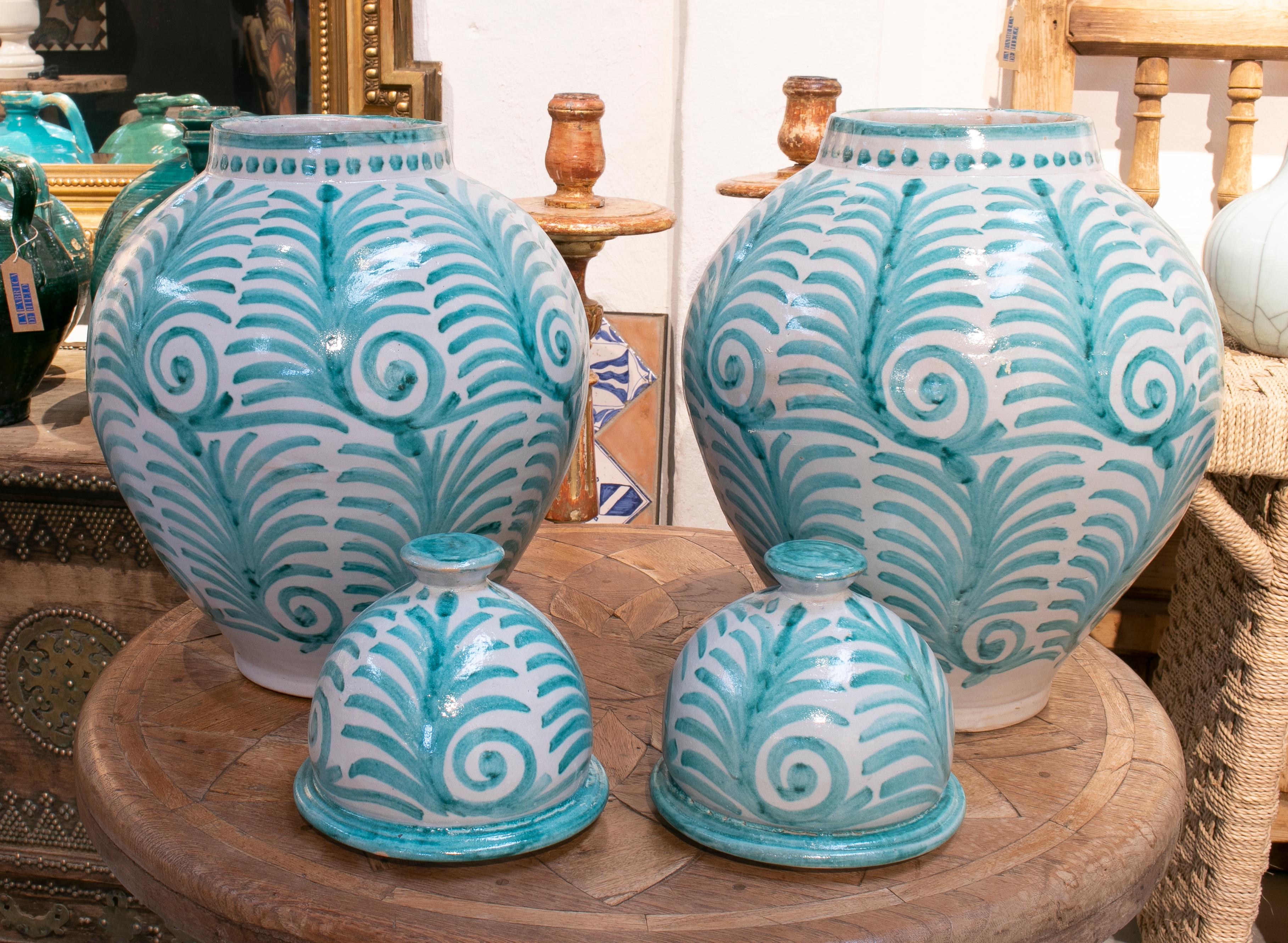 Contemporary pair of hand painted glazed terracotta vases with lids.