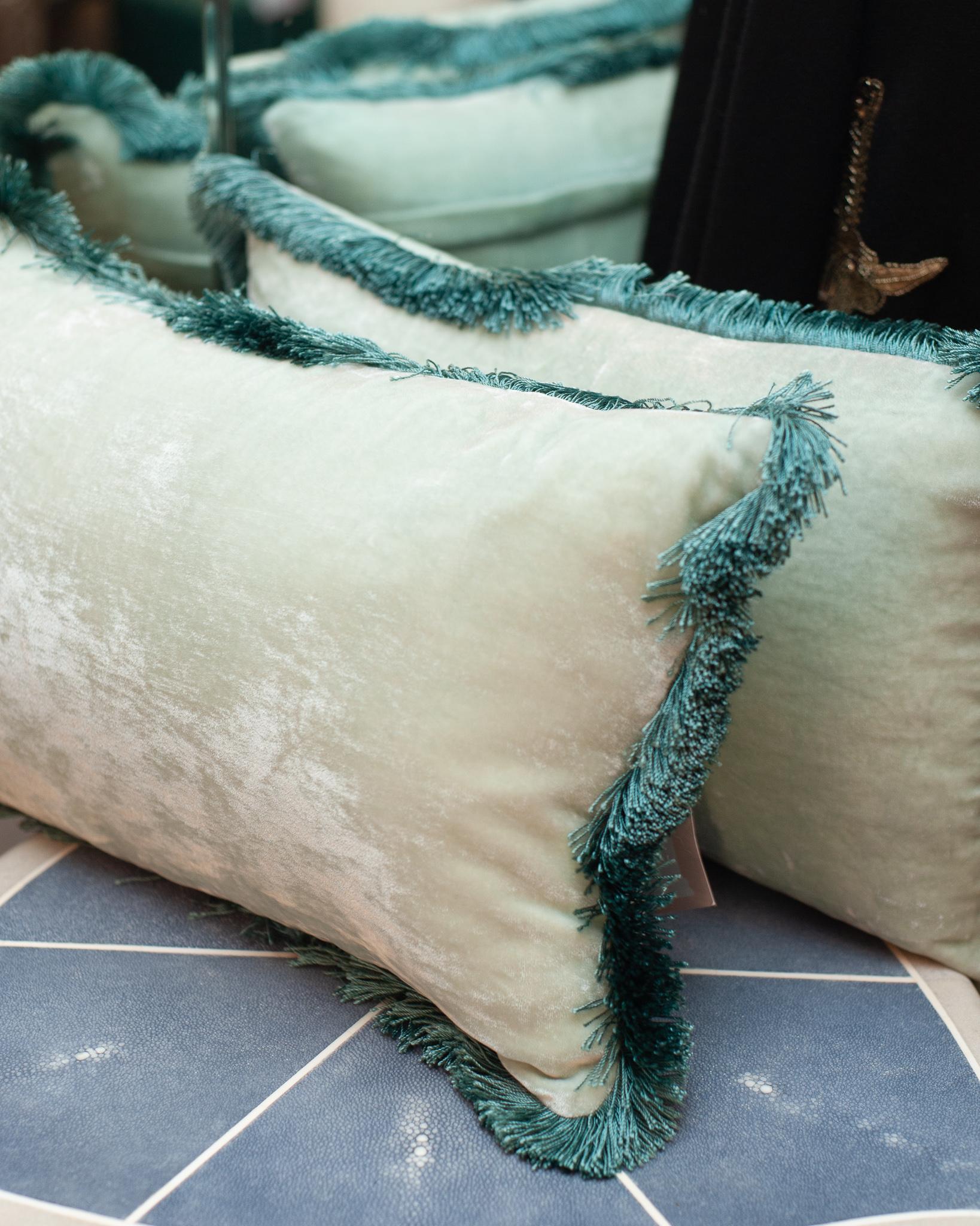 A pair of light blue silk velvet cushions from Anke Dreschel featuring fringe trim, rectangle shape and concealed rear zip fastening. Filled with 100% Canadian feather and down.