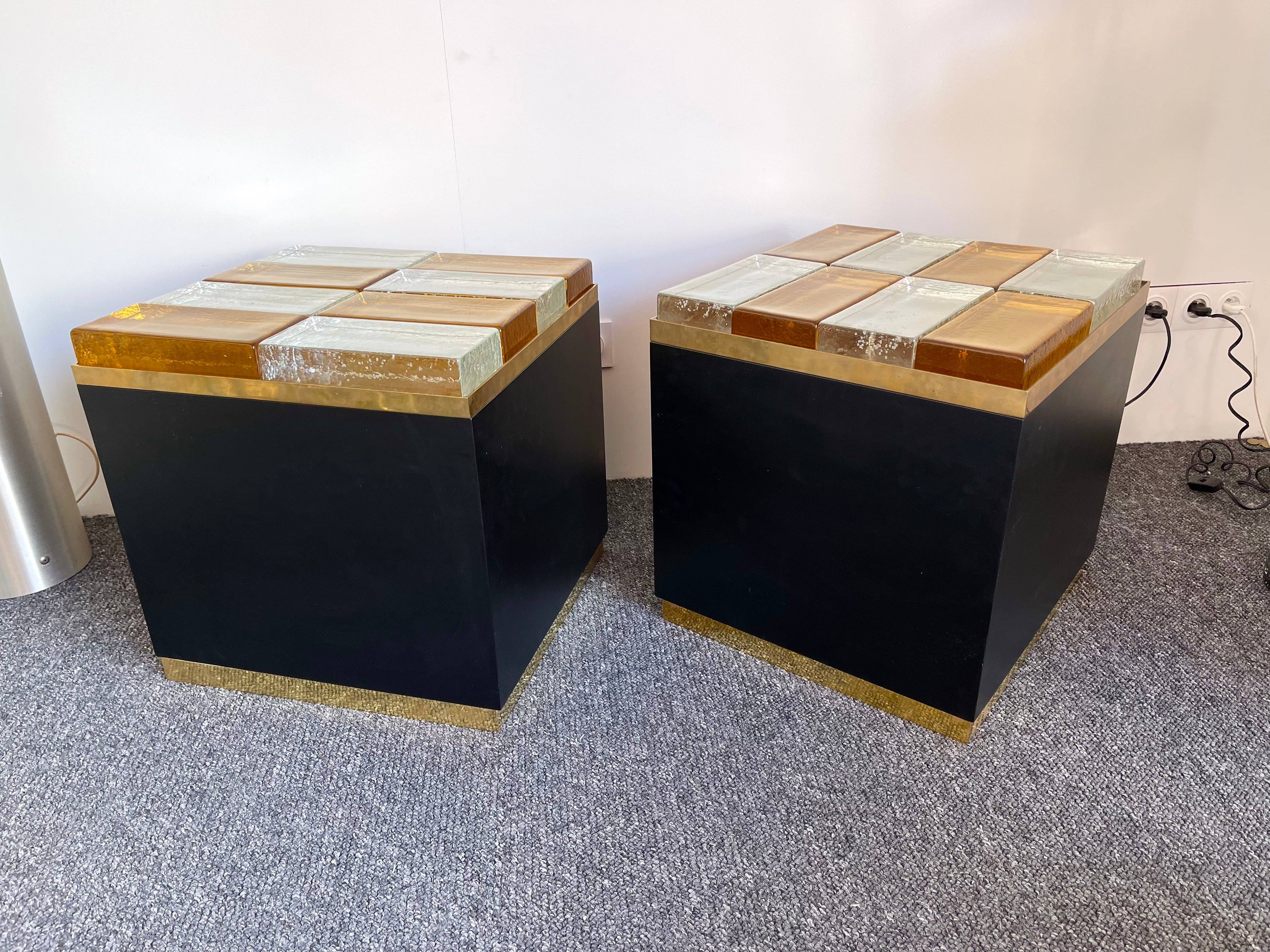 Pair of lightning light lamp side end low coffee cocktail bedside tables or nightstands in black mat lacquered wood, brass and massive block brick of yellow and clear bubble Murano glass. Contemporary work by a small artisanal Italian design