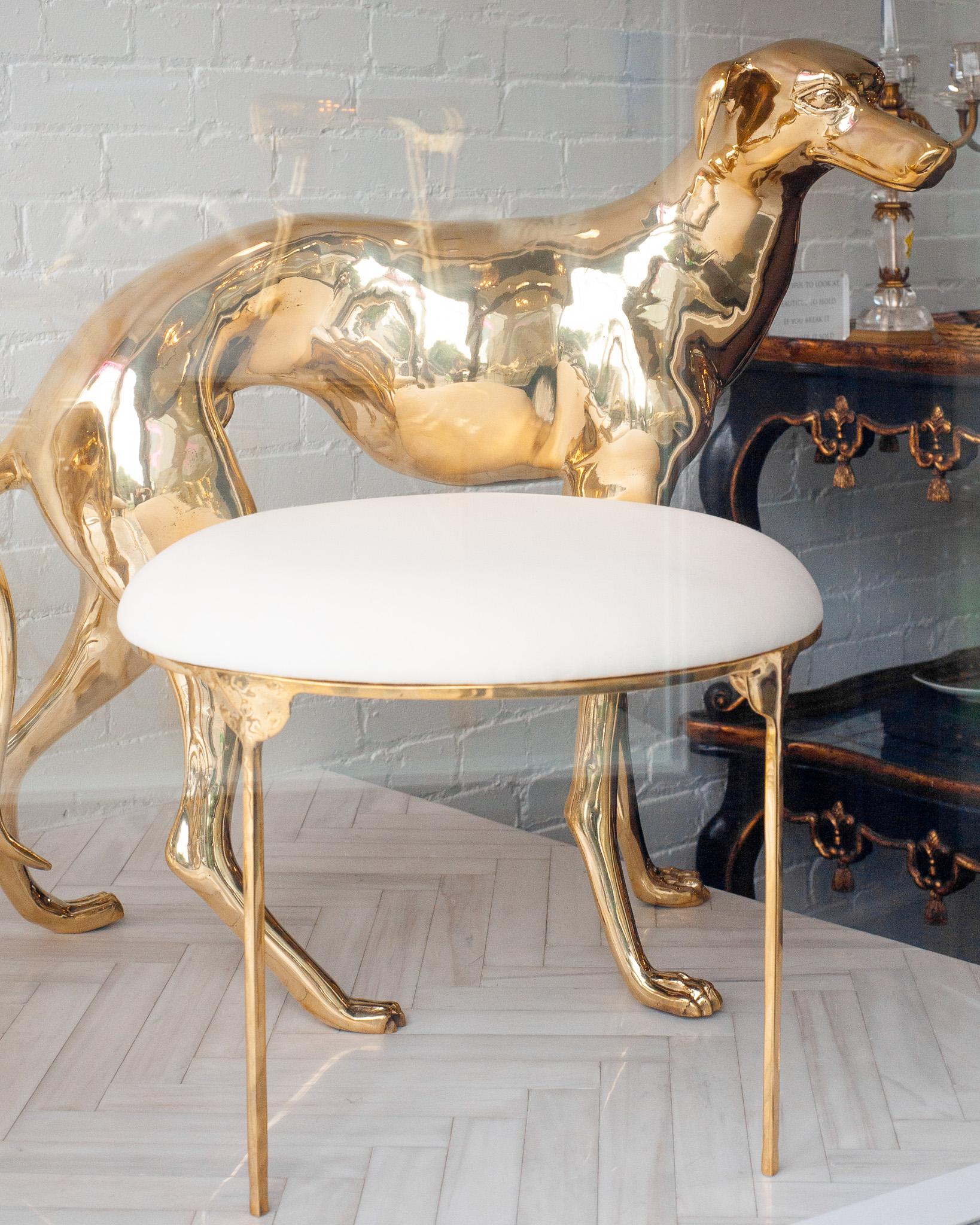 Paire de chaises contemporaines en forme de lévrier - Sculpturaux et imposants, ces lévriers grandeur nature sont moulés en laiton poli, leurs formes épurées incarnant à la fois l'élégance et la force. Chaque figure supporte une assise circulaire