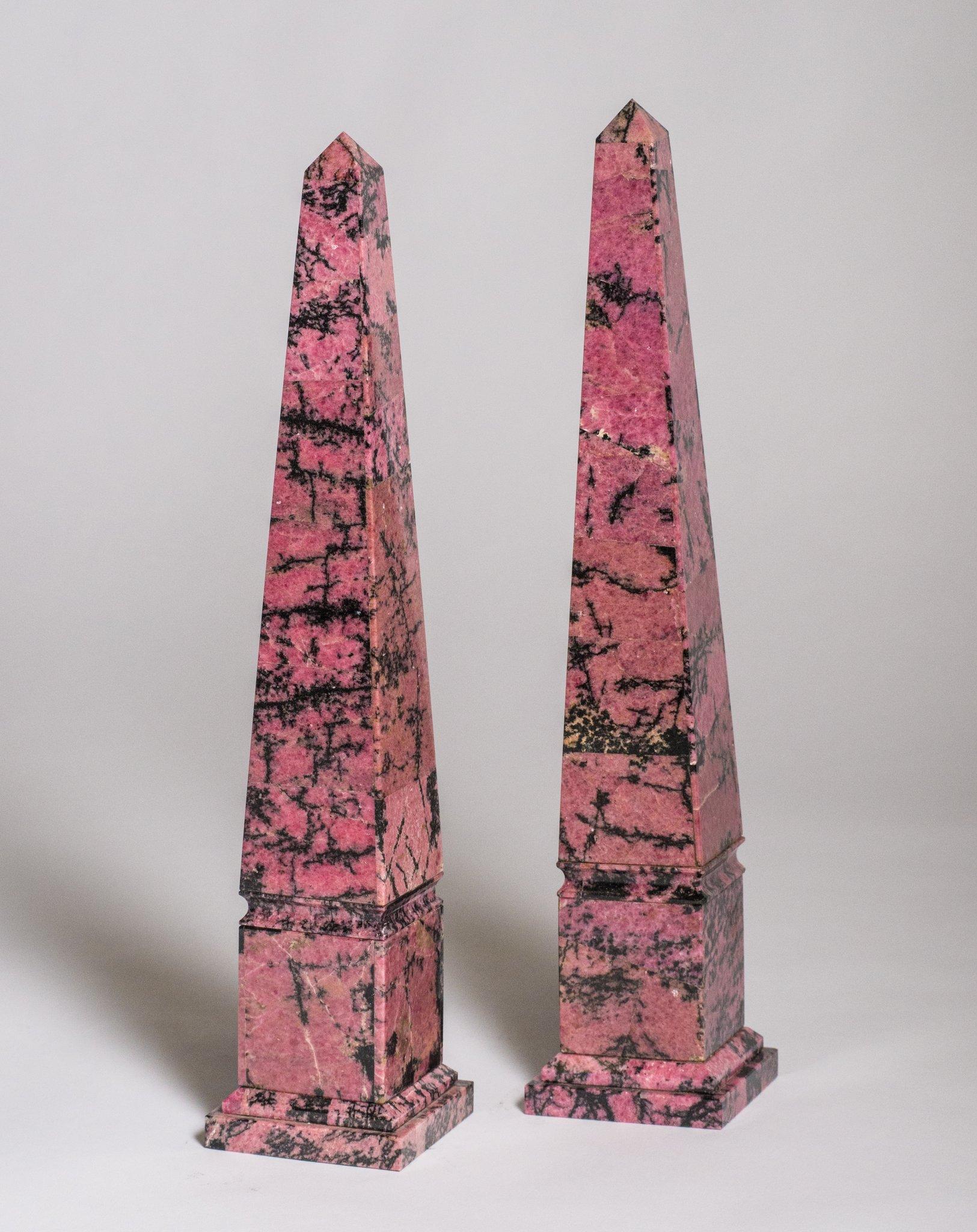 Dieses spektakuläre Obeliskenpaar ist aus Rhodonit gefertigt, einem Naturstein, der von dem Wort rhodon abstammt, das im Griechischen Rose