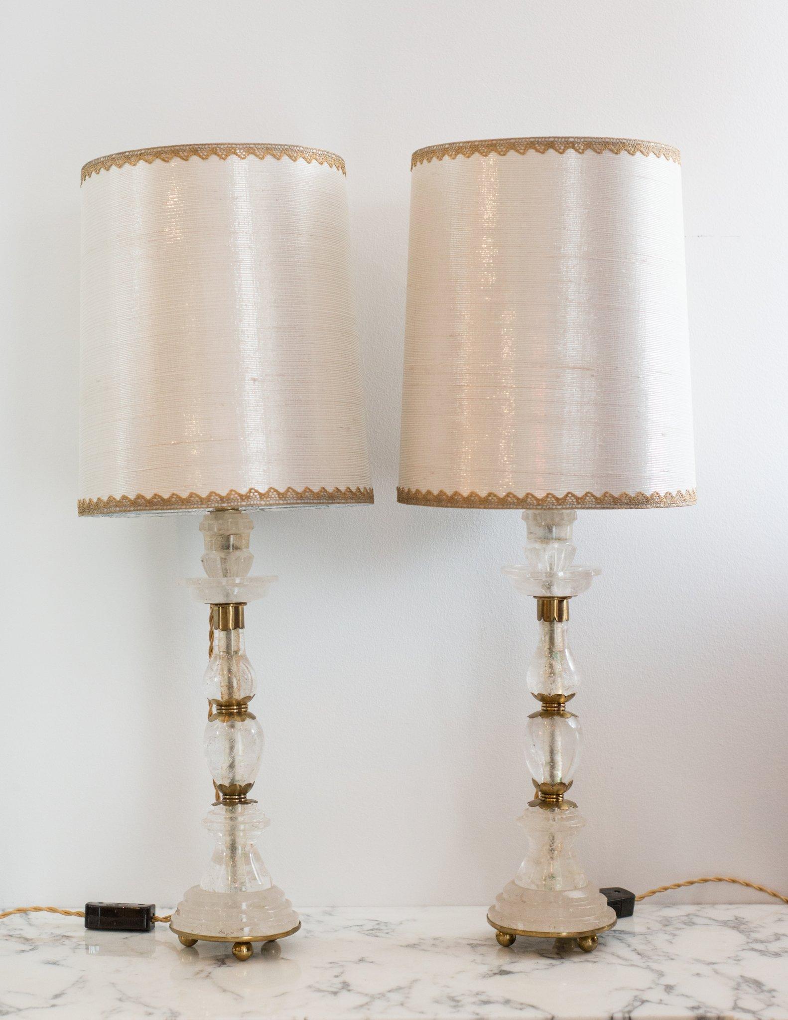This pair of rock crystal and bronze lamps was sourced in Paris. Rock crystal has long been used in decoration and many ornate pieces are exhibited in museums around the world. The stunning shades are handcrafted from metallic silk with vintage gold