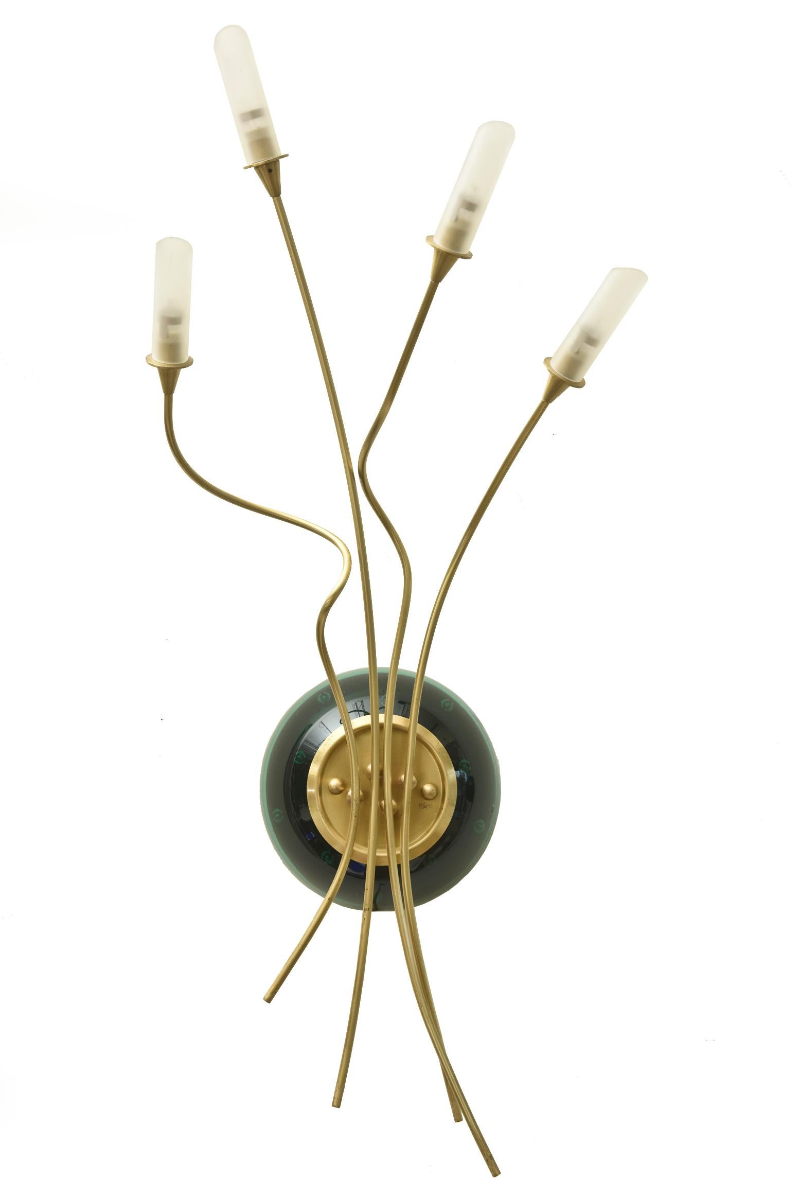This pair of custom contemporary combination of Murano glass infinity lights and gold plated brass armature make for sculptural wall sconces. Their interested arms create a movement on the wall. The emerald green glass middle portion when lite up