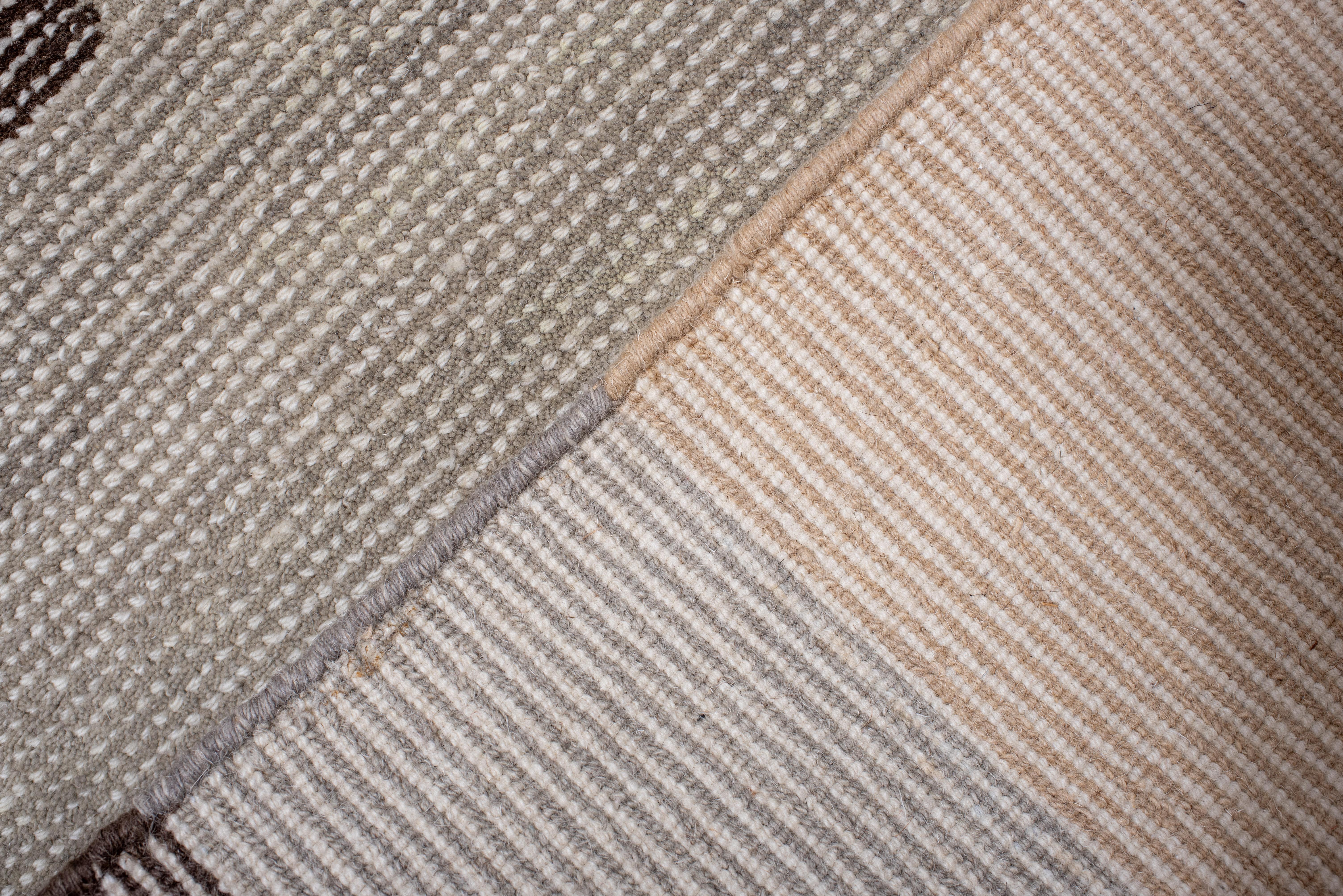 Si tratta di un tappeto lavorato a mano che presenta una composizione geometrica straordinariamente moderna, che enfatizza l'arte della semplicità e delle forme audaci. Il gioco di toni morbidi e tenui - come il beige sabbia, il grigio pietra e gli