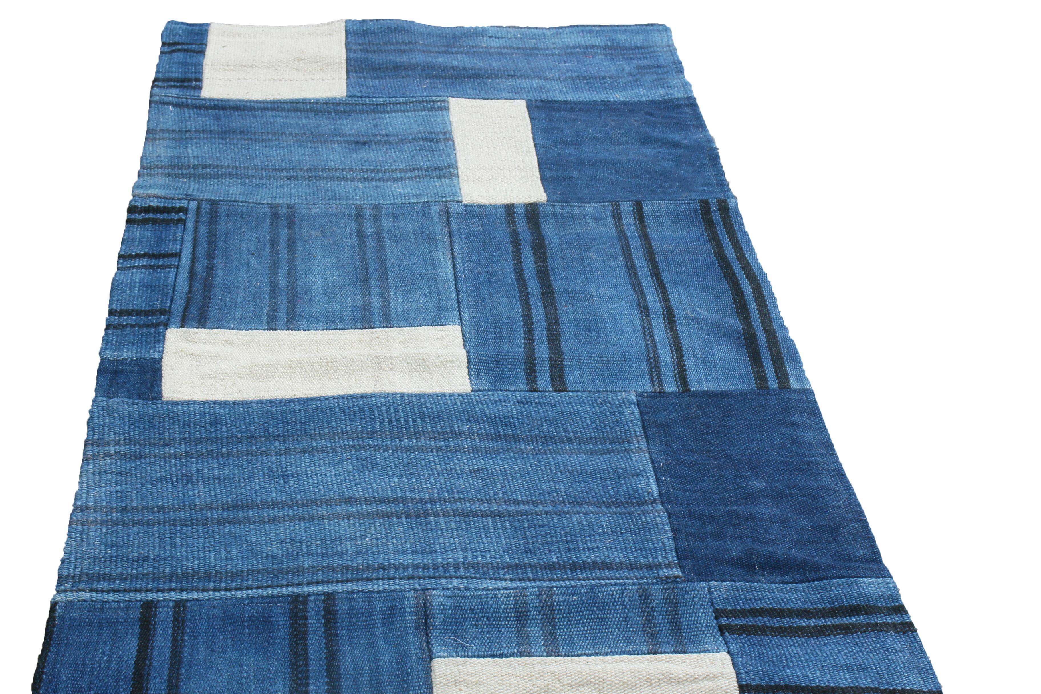 Originating from India, this contemporary wool runner enjoys a patchwork geometric field design with abrash hues of abrash Prussian blue, white, and linear black colourways in a borderless, conservative design.