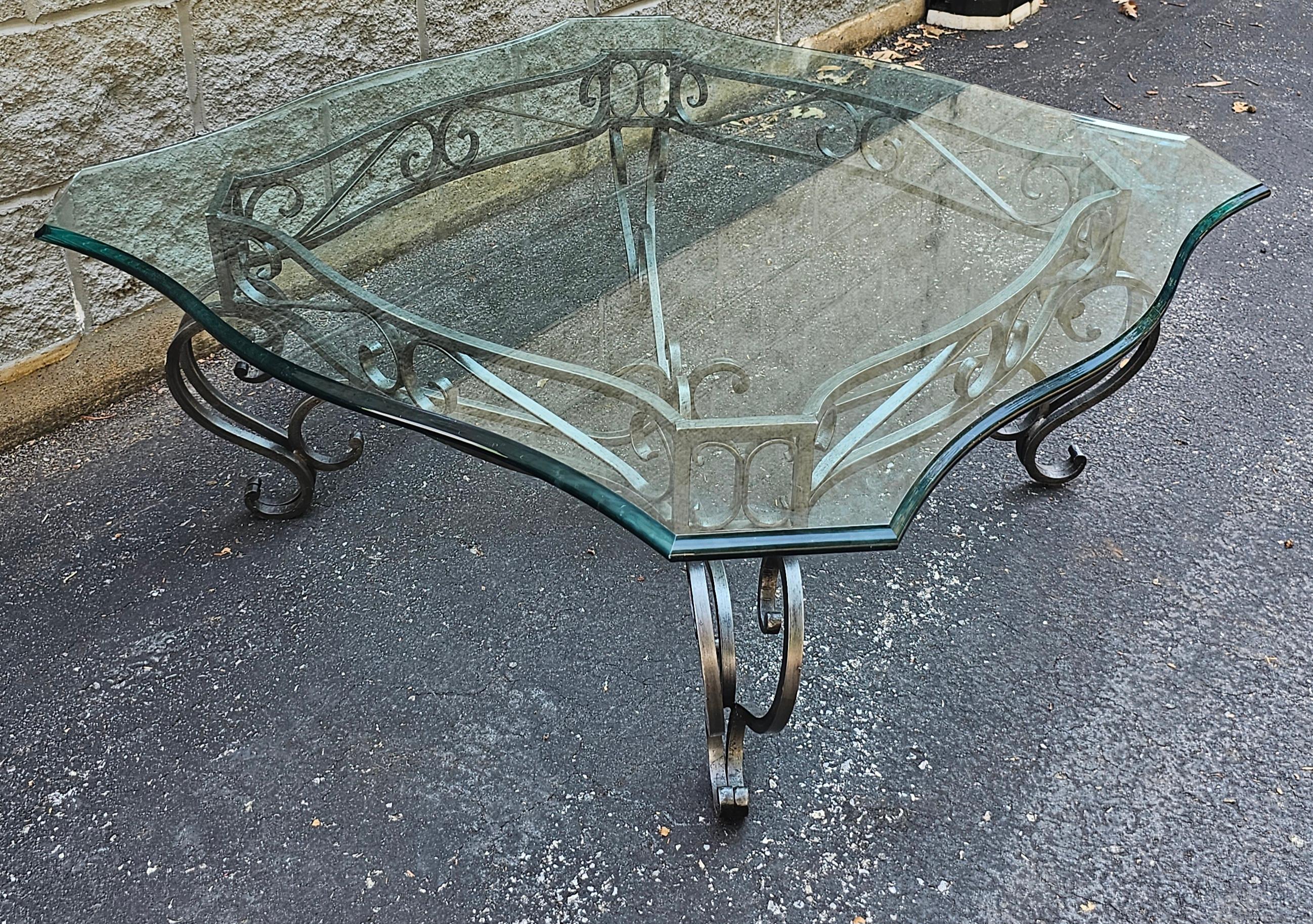 A contemporary iron metal base and glass top cocktail / coffee table. Measures 38