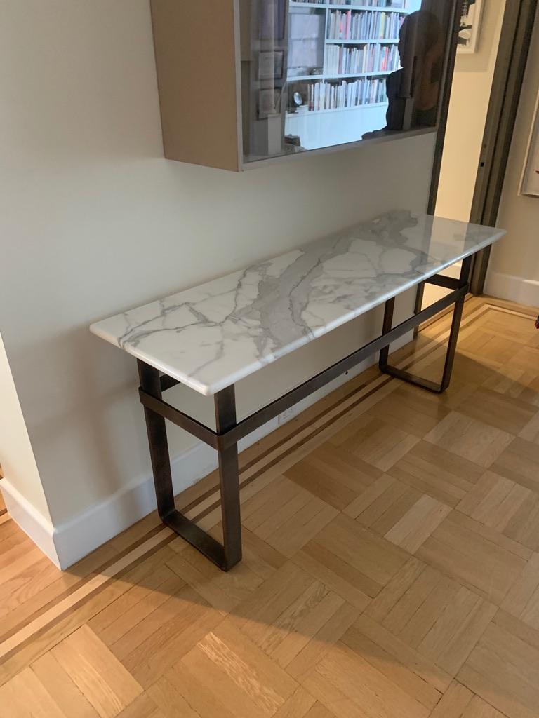 The Axel Console, an original design, is a contemporary Minimalist patinated stainless steel and marble top console designed and produced in Vermont by Scott Gordon. It features a satin stainless steel base with a hand applied patina which supports