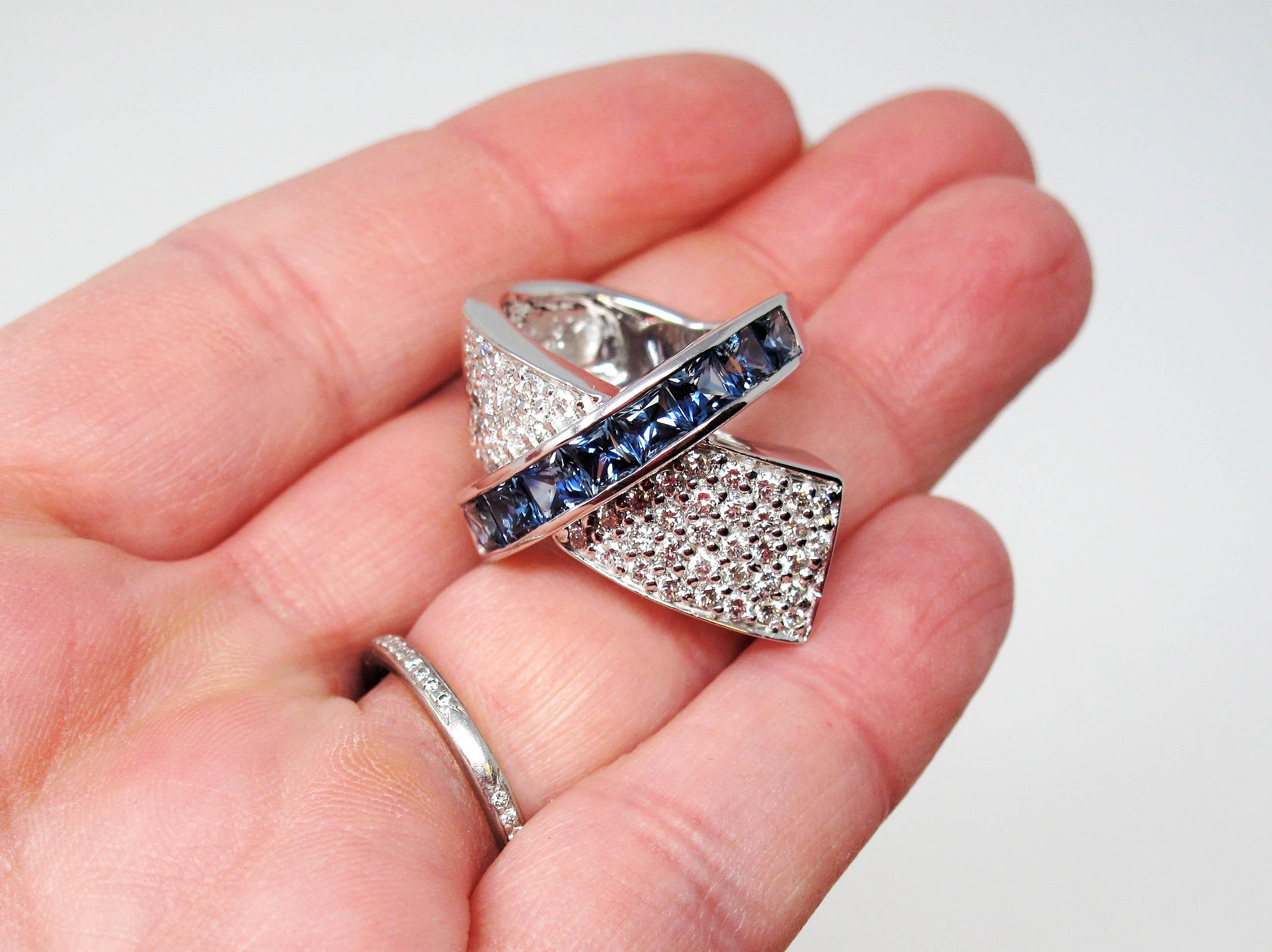 Ring size: 5

This stunning diamond and sapphire ring absolutely exudes modern sophistication This ultra  contemporary piece glitters from all directions with its sparkling pave diamonds, while the brilliant blue sapphires add a gorgeous pop of