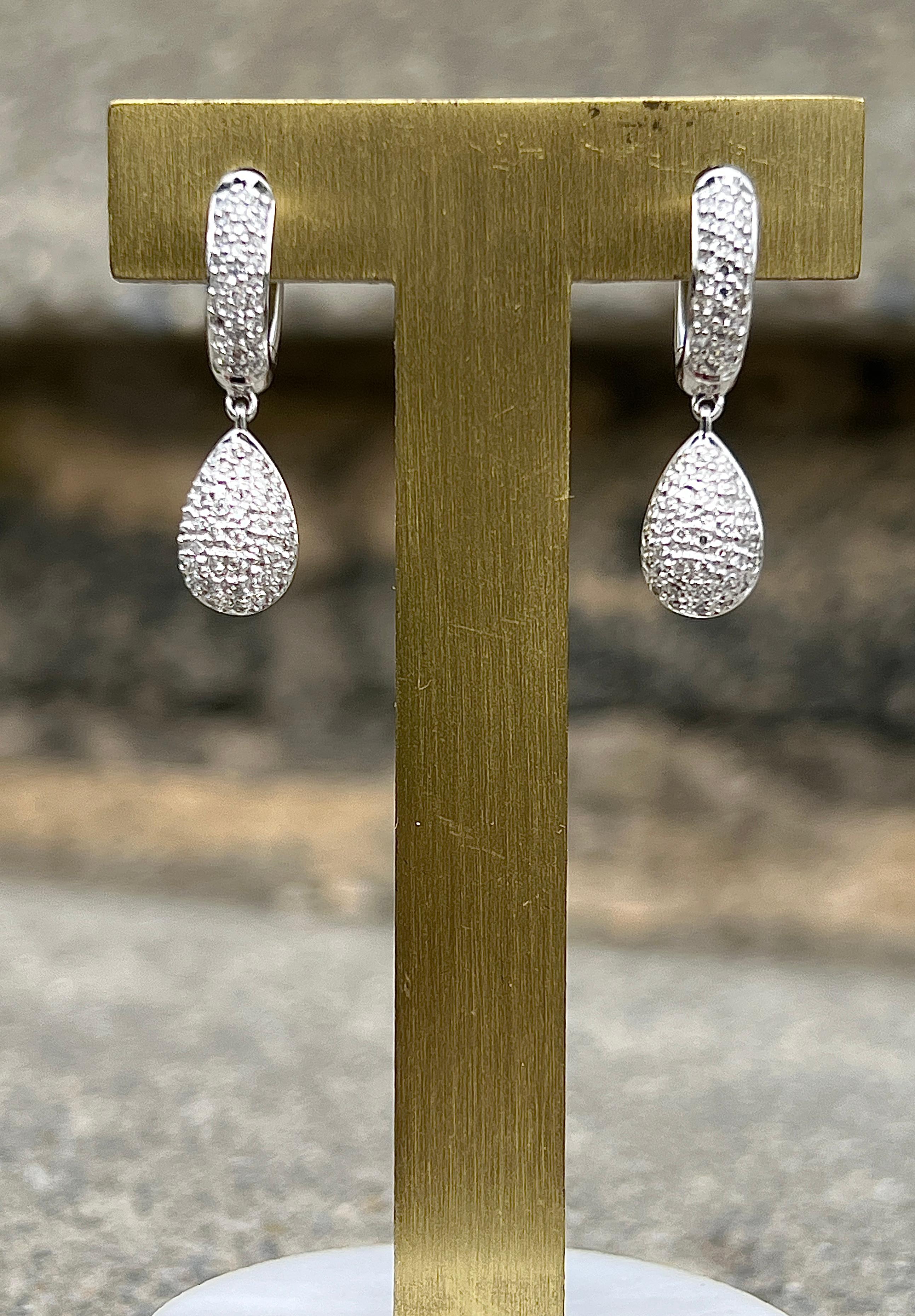 This contemporary pair of 14K white gold drop earrings sparkles with a delicate arrangement of 116 pave-set single cut diamonds, totaling approximately 0.29 carats. With G/H color and SI2/I1 clarity, the diamonds lend a soft, elegant shimmer to the