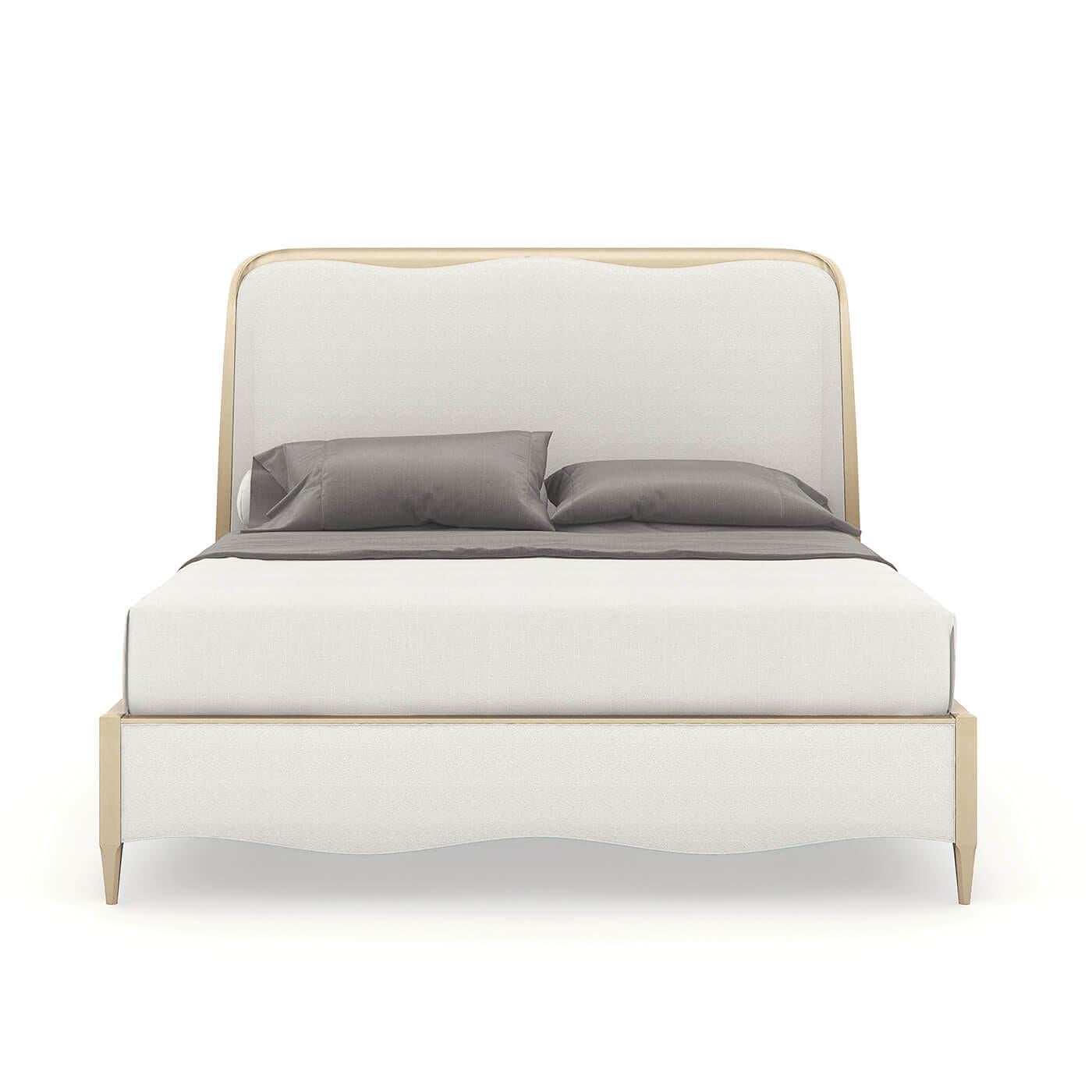 A contemporary pearl finish king bed with a gracefully curved headboard. This beautiful bed has a soft and serene design, its flowing lines are inspired by forms in nature. It has an upholstered headboard, footboard, and rails and sits on tapered