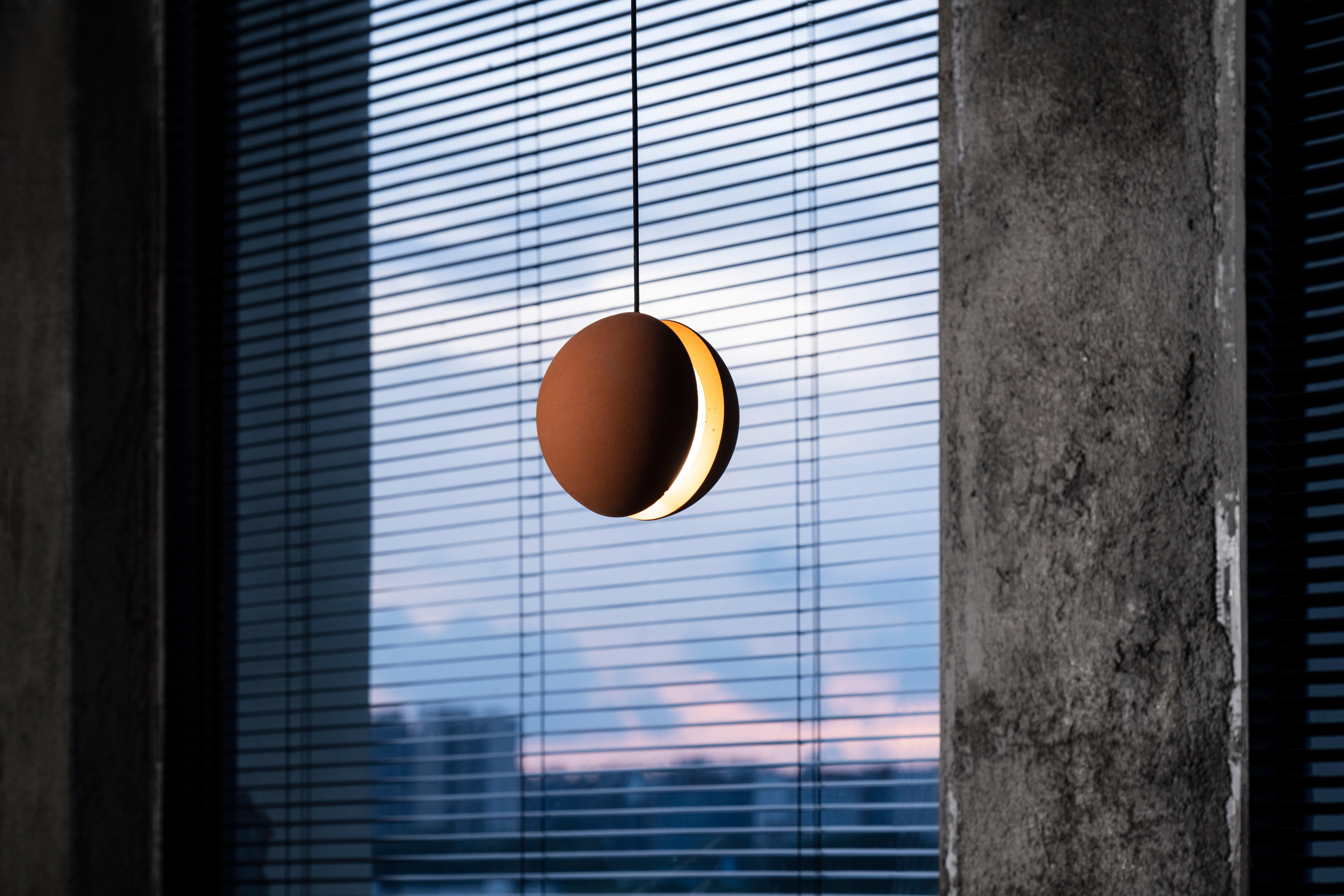 Pendant lamp 'E-mars' by Nongzao x Bentu Design.
Material: Terracotta 
Color: Earthy brown 

Measures: 12,7 cm high, 13 cm diameter
Wire: 3 meters (black)
Lamp type: AC 100-240V 50-60Hz  9W - Comptable with US electric system.

Variations:
- Color: