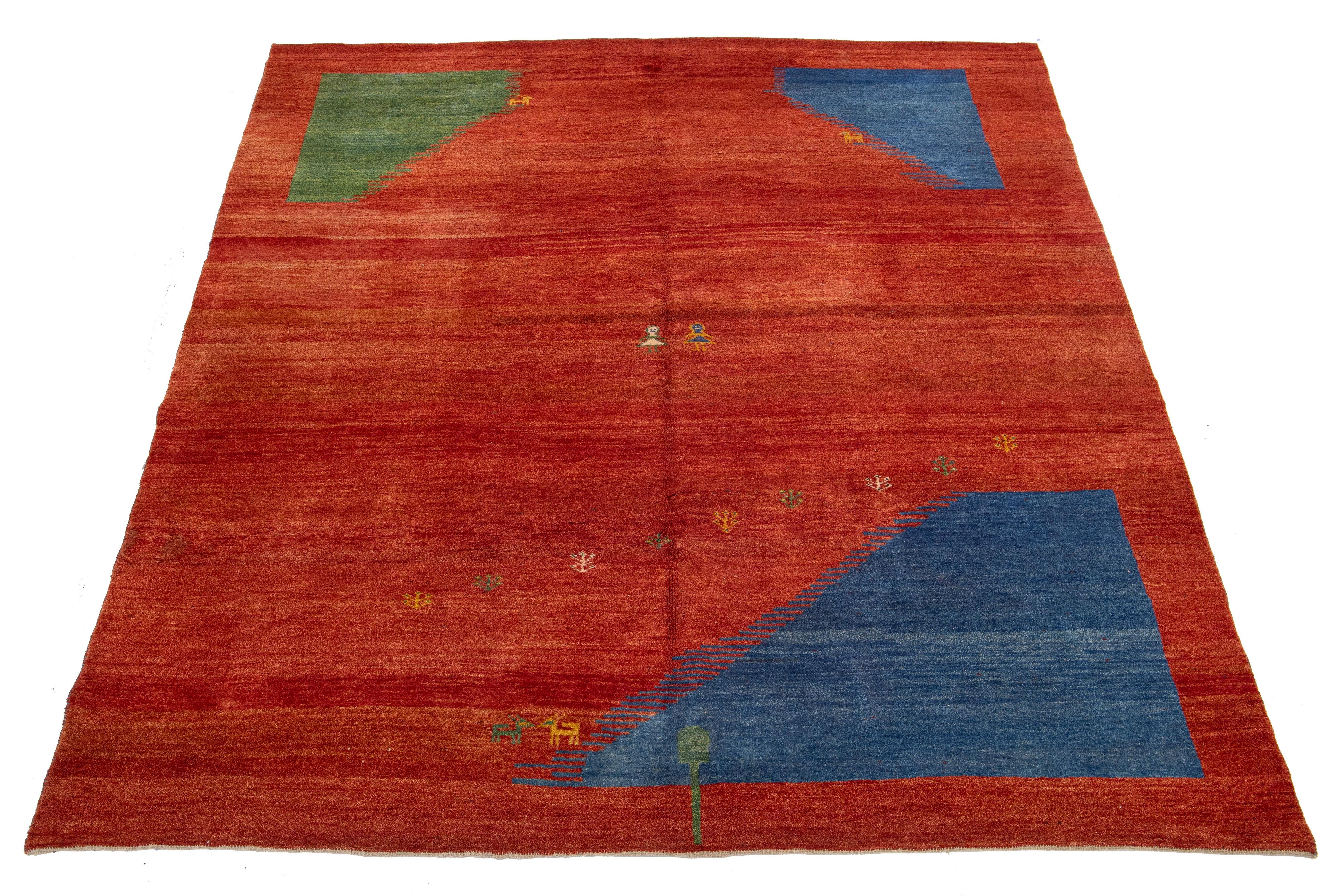 Dieser moderne Gabbeh-Teppich ist handgeknüpft und mit einem modernen geometrischen Muster versehen. Der rote Sockel ist mit grünen und blauen Details akzentuiert.

Dieser Teppich misst 8'6'' x 11'.



