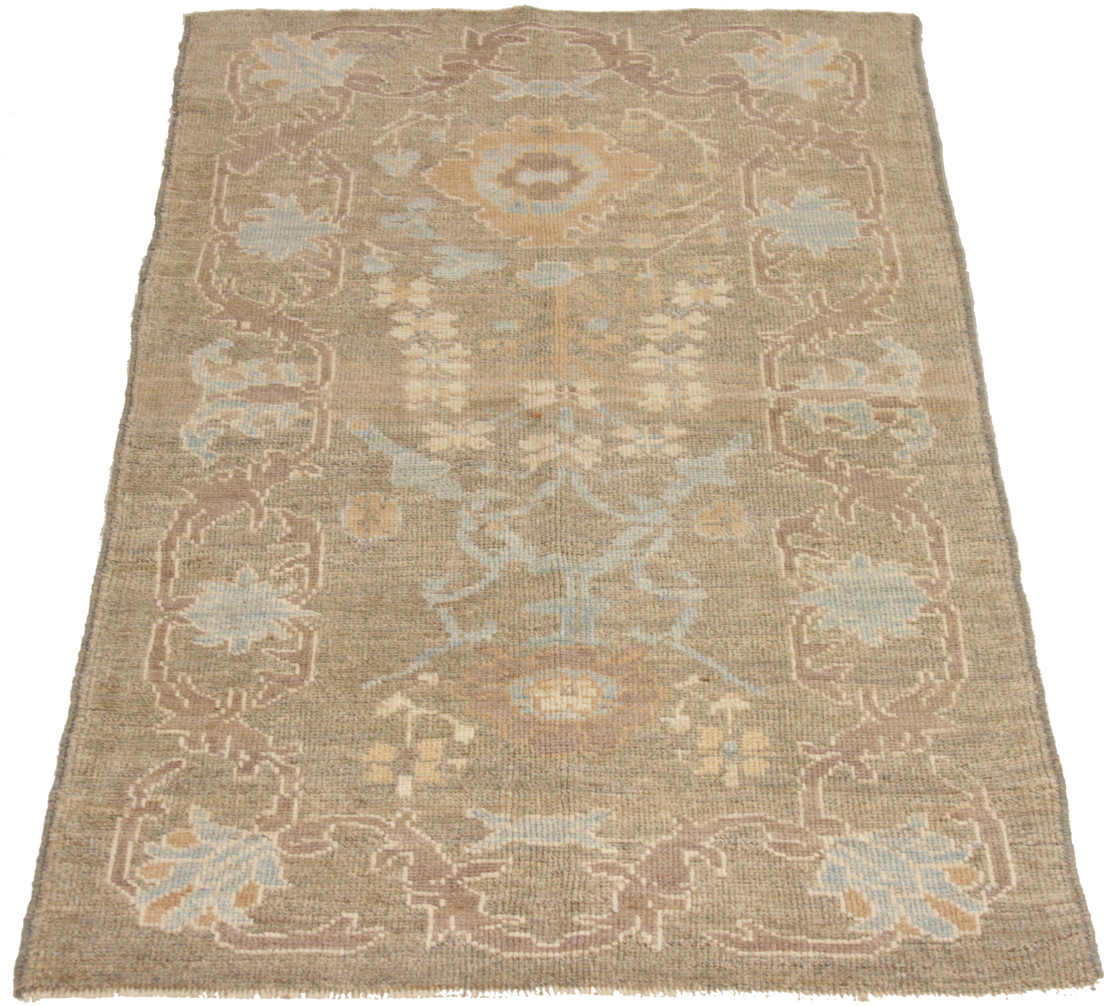Handcrafted Persian rug made from the finest sheep’s wool and colored with 100% organic vegetable dyes that are safe for humans and pets. It shows a traditional Oushak design featuring a beige field with blue and brown floral patterns. It’s an