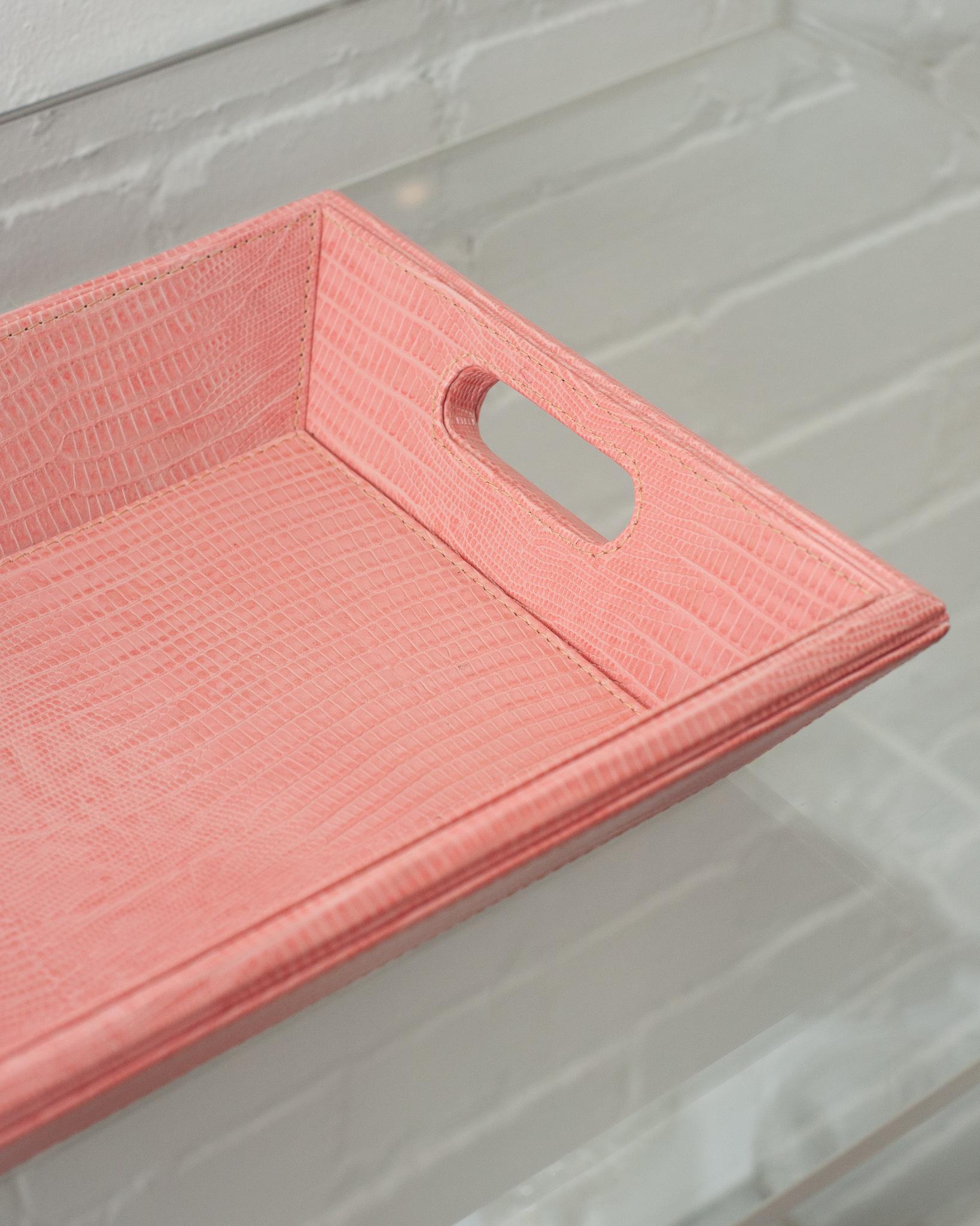 A beautiful pink lizard embossed leather tray, perfect for the desk, bedside table, or use as a serving piece. Fully wrapped in embossed leather with stitched panels, each tray has two openings for carrying.