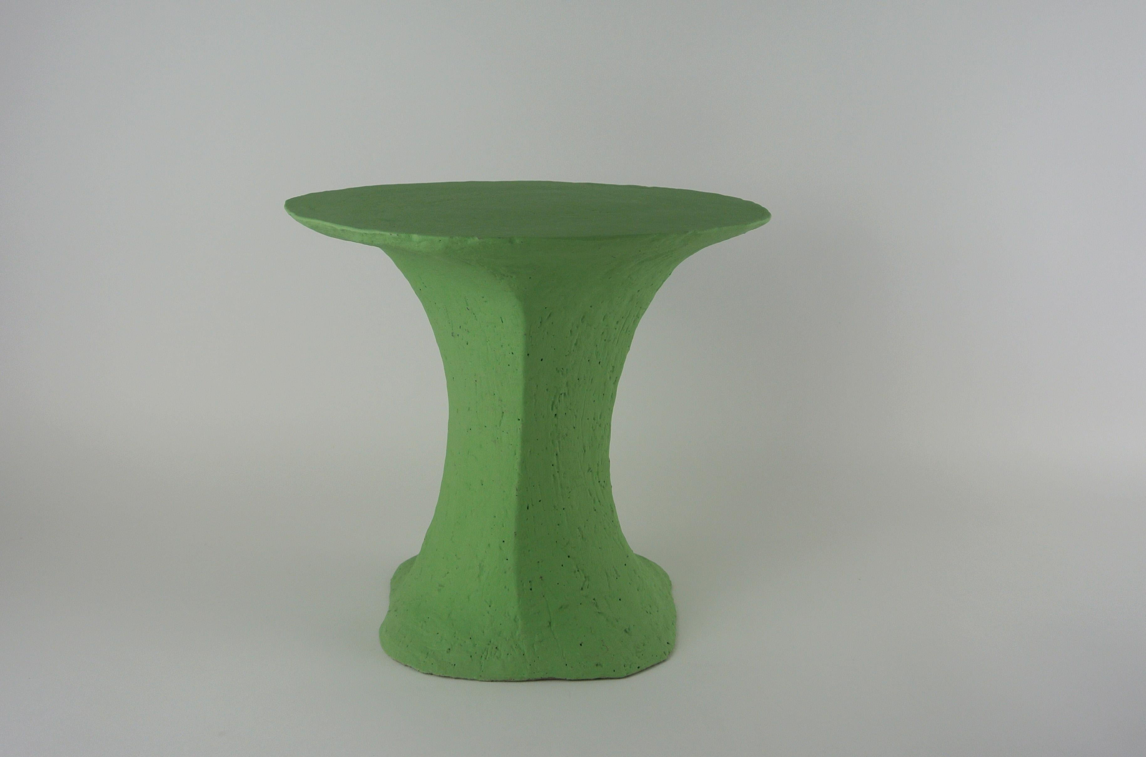 Asymmetric platform table made from rough grey stoneware with matte lichen green engobe. Grey fire sand subtly visible on the surface.