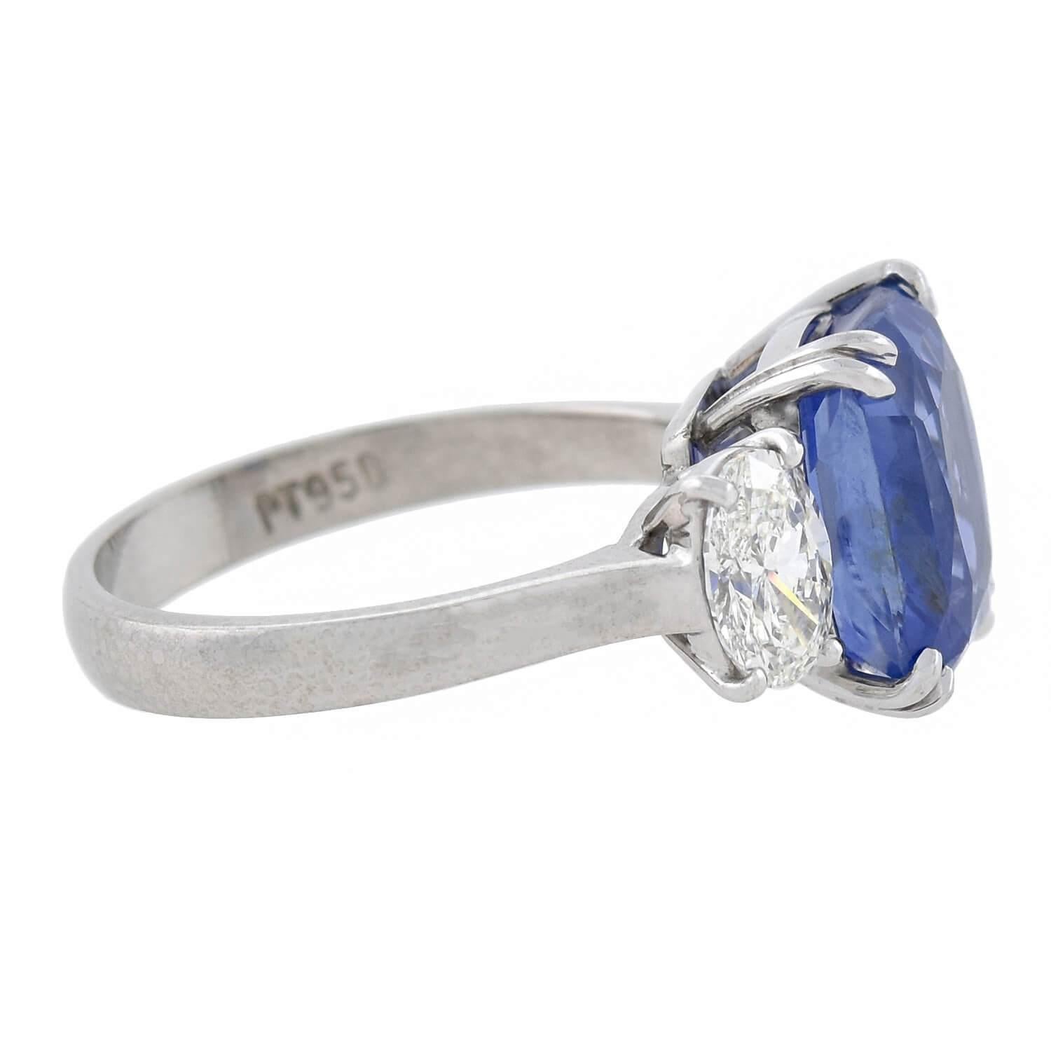 An exquisite contemporary sapphire and diamond ring! Crafted of platinum, this stunning piece holds a gorgeous natural sapphire at the center, framed by sparkling diamonds at either shoulder. The Ceylon (Sri Lankan) sapphire has an exact weight of