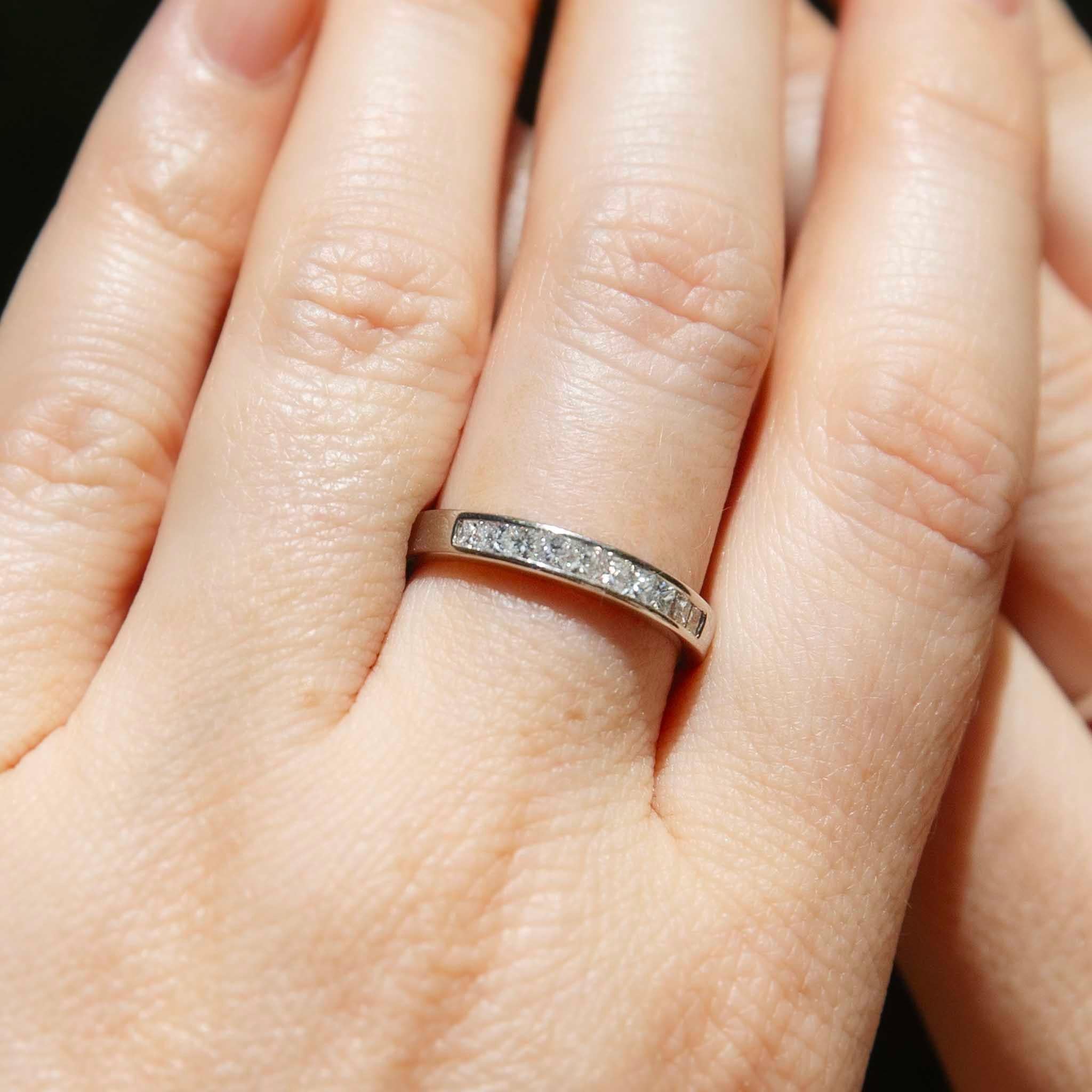 Der Bailey-Ring ist ein Klassiker der schlichten Eleganz. Geschmiedet aus Platin und mit kanalgefassten Diamanten im Prinzessinnenschliff, die auf der Vorderseite glitzern, wird sie Sie und die Ihren über Generationen hinweg als Symbol der Liebe und