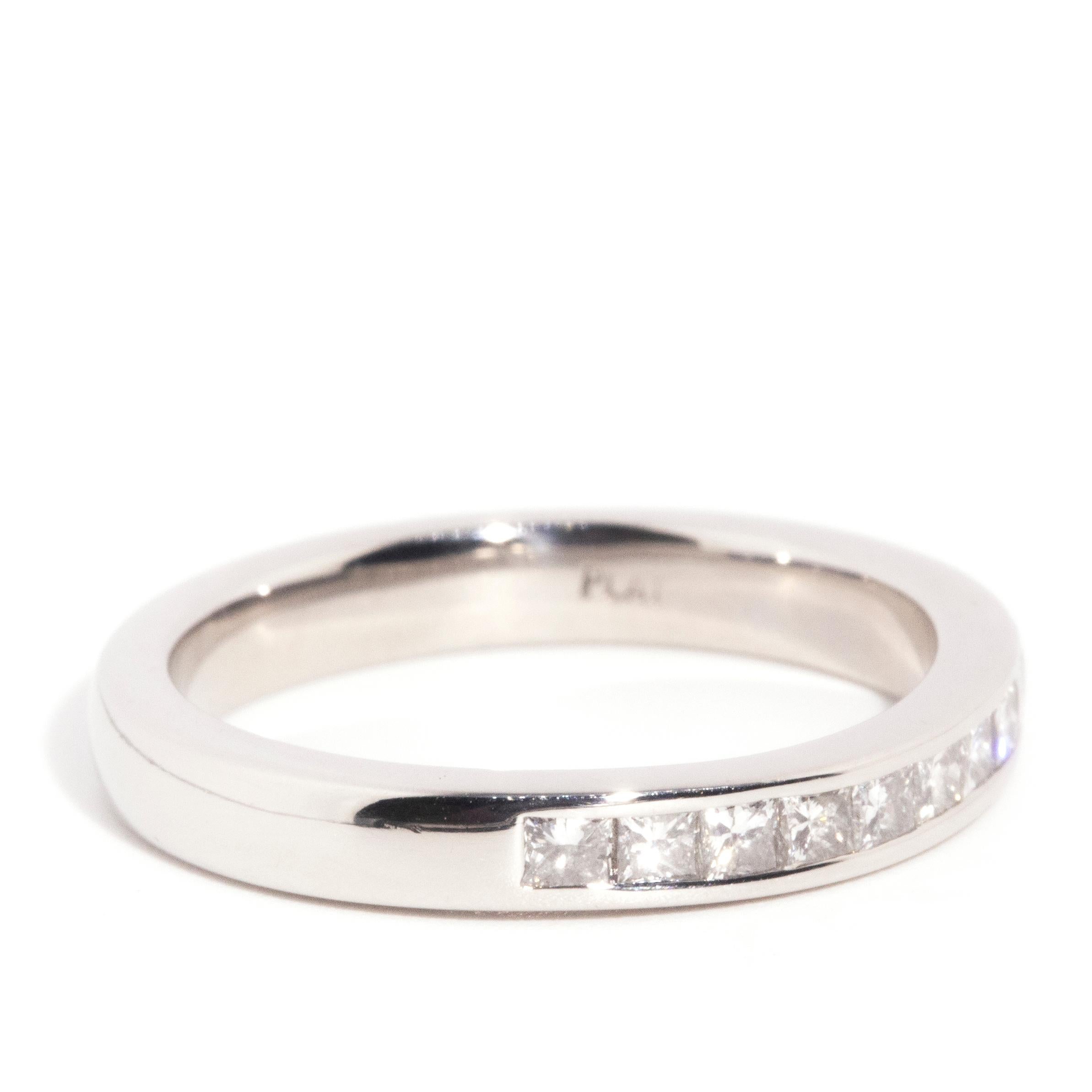 Forged in platinum, this lovely contemporary ring features a scintillating row of nine channel set princess cut diamonds along the front of a gleaming white band. We have named this darling adornment The Raziel Ring. Perfect to wear alone or stacked