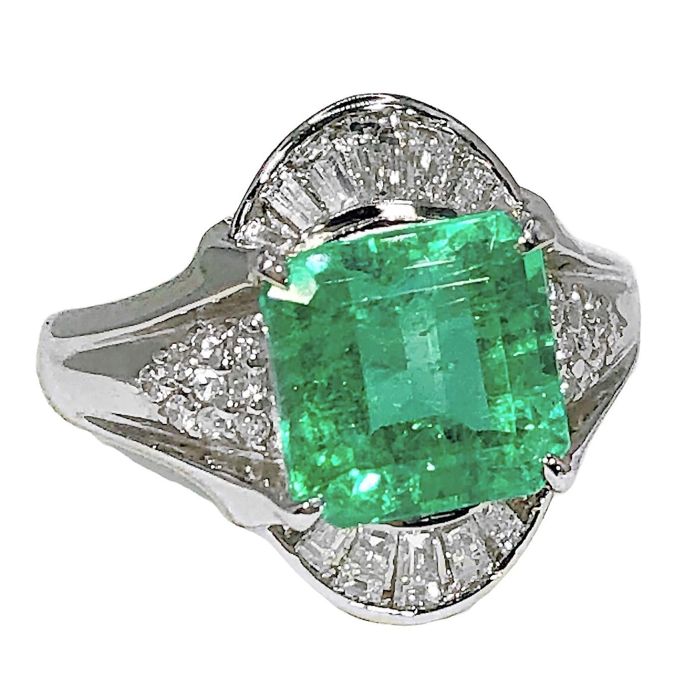 This delicate platinum cocktail ring has, as it's principle feature a lovely and brilliant, square emerald cut natural emerald weighing exactly 3.48ct. Surrounding the center stone are assorted tapered baguette and brilliant cut diamonds with a