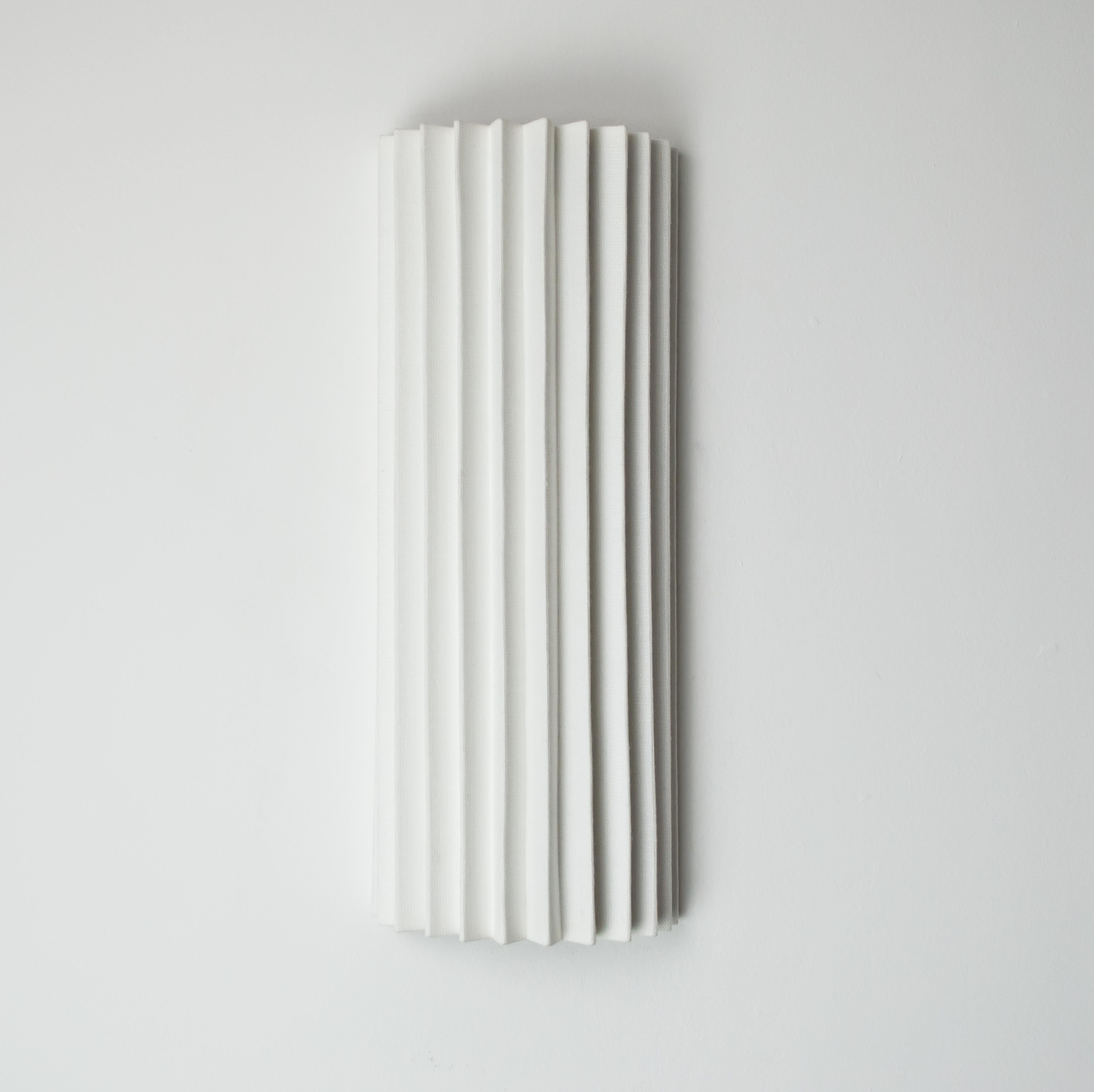 Limited edition handmade Pleated Wall Light.  The white linen gives the light a soft glow and the delicate shape of the light is carefully fitted around a brushed stainless steel armature that holds each pleat in position.  The simple geometric