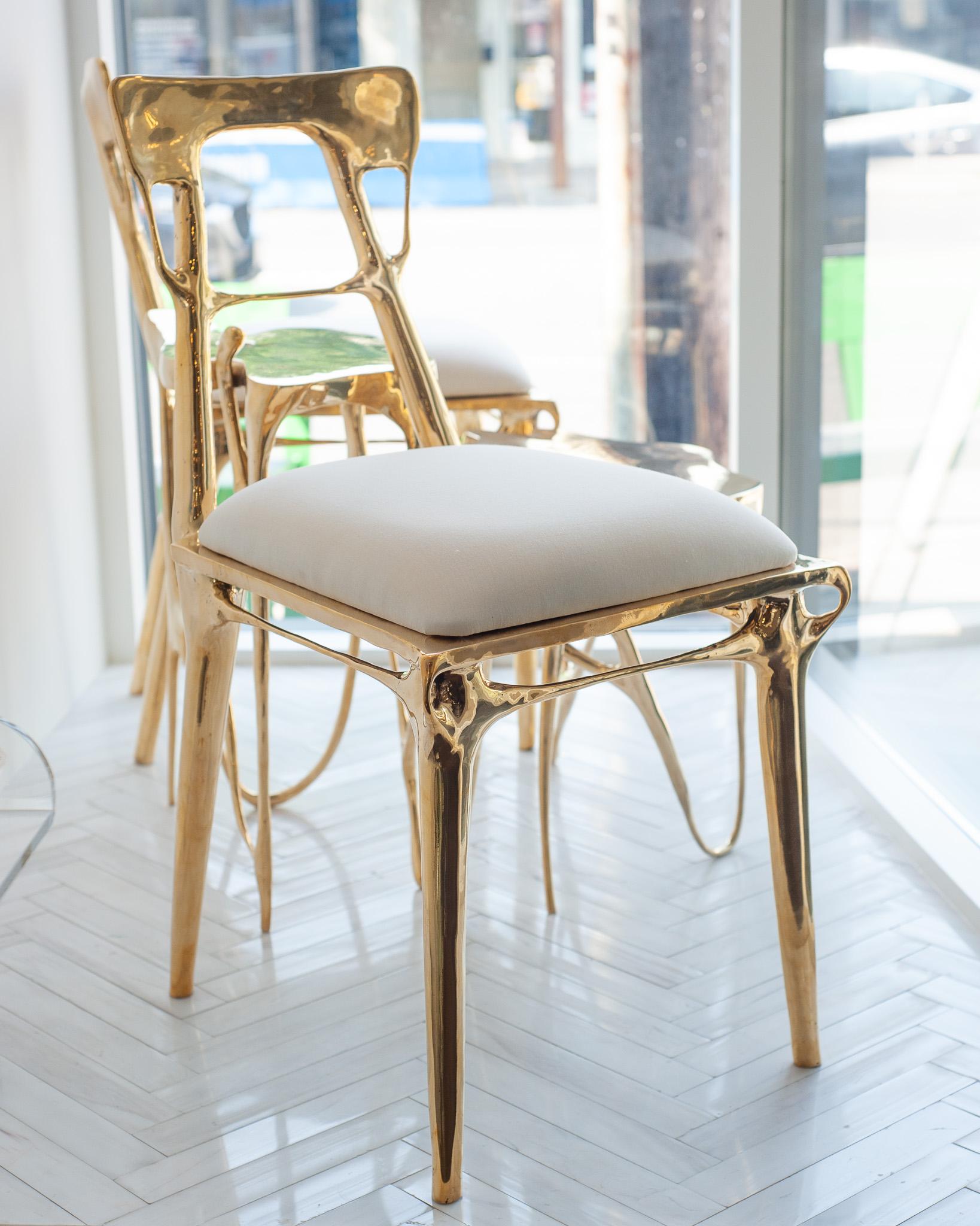 Realizzata in ottone fuso lucido, questa sedia emana una presenza radiosa pur mantenendo una forma fluida e scultorea. La sua superficie lucida riflette la luce attraverso linee sinuose che attirano lo sguardo lungo i contorni della cornice. La
