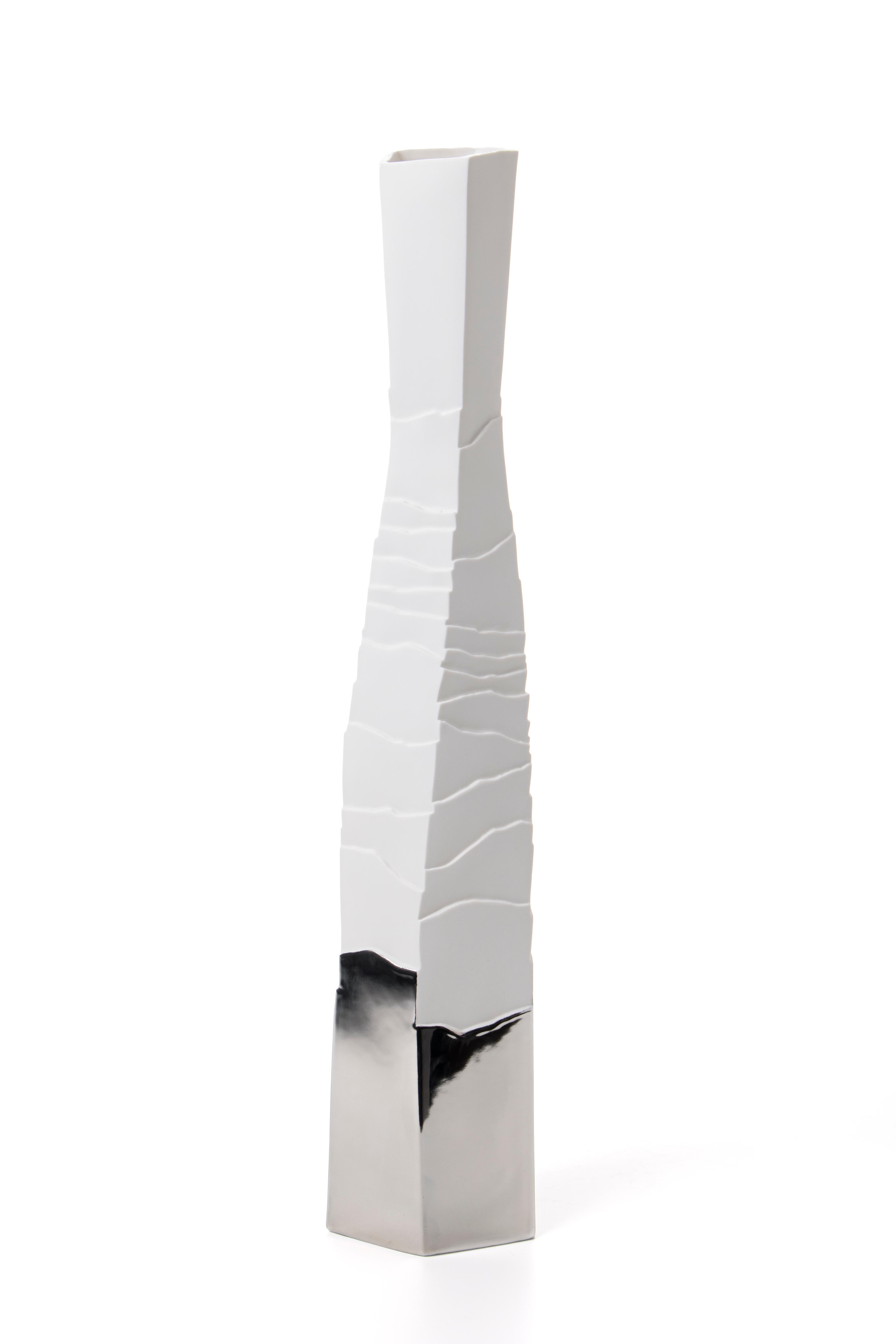 Dense layers and smooth surfaces interrupted by irregular ridges, memory of eroded rocks.
Contemporary porcelain object for elegant interiors. 
This vase is decorated by hand with precious platinum, fixed through an additional meticulous firing