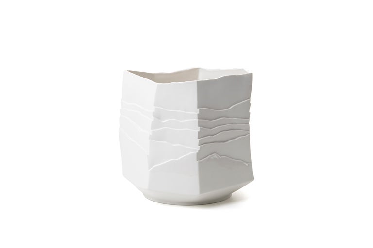 Dense layers and smooth surfaces interrupted by irregular ridges, memory of eroded rocks.
Contemporary porcelain object for elegant interiors. 
The lower part of this vase is decorated with a shiny transparent glaze which creates an elegant