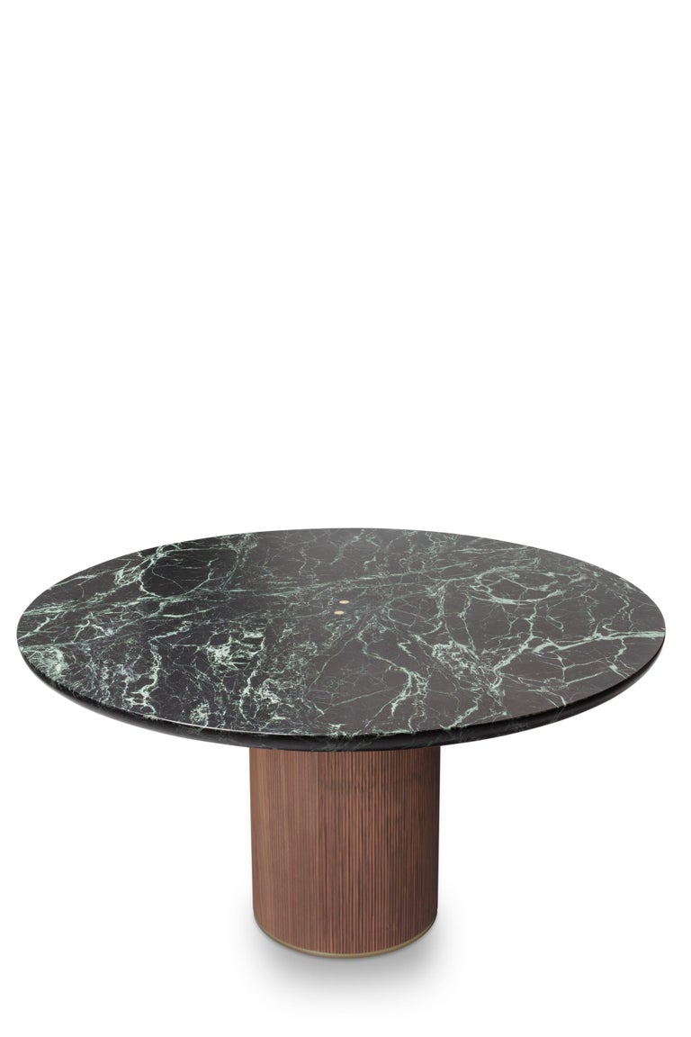 The QD05 dining table is made of green marble and a walnut wood base with beautiful details made in brass. Its elegant simplicity makes it adaptable to many spaces.