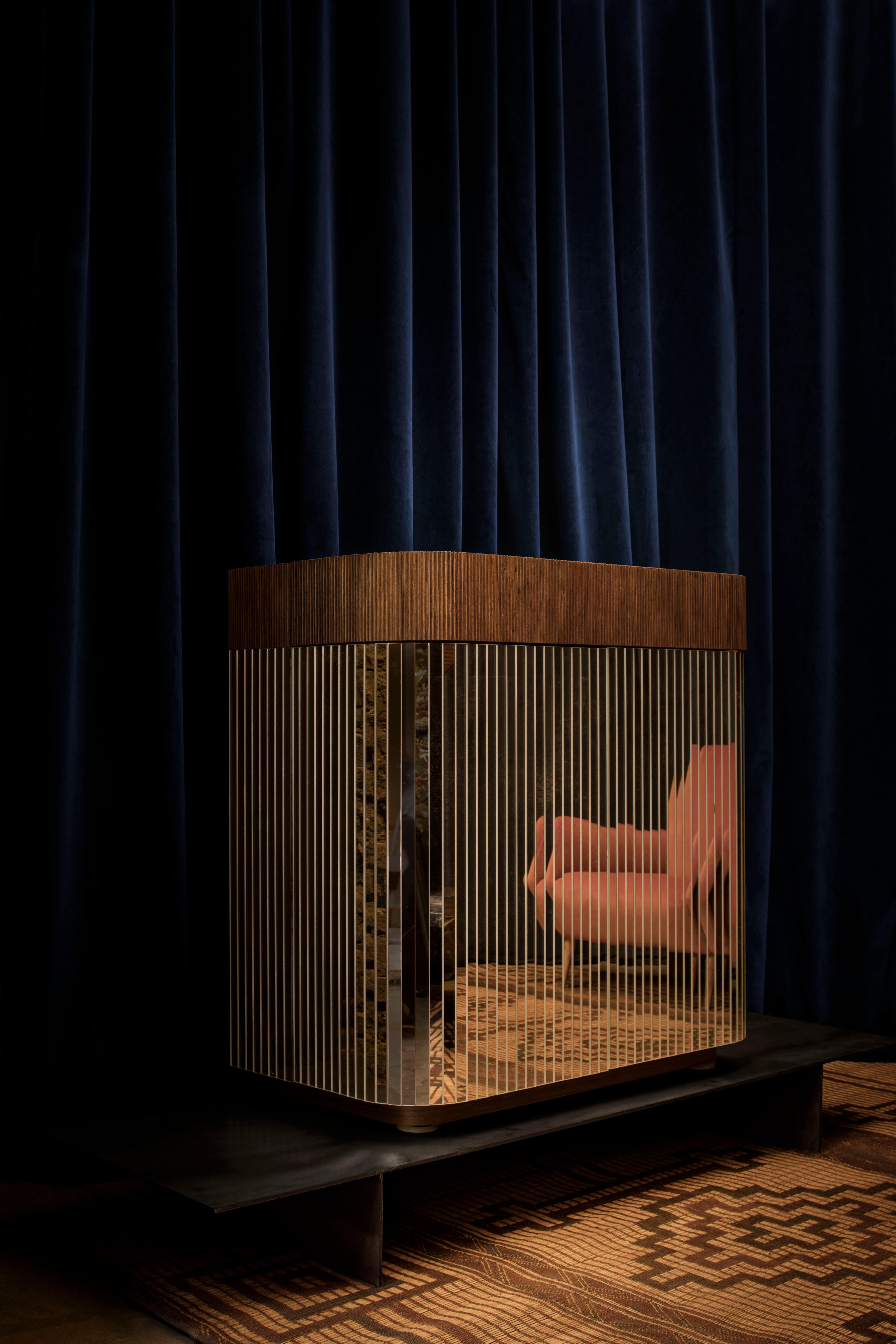 The QD20 bar on the outside is made with ribbed walnut and mirrors, instead on the inside is made with walnut wood, ribbed glass and brass.