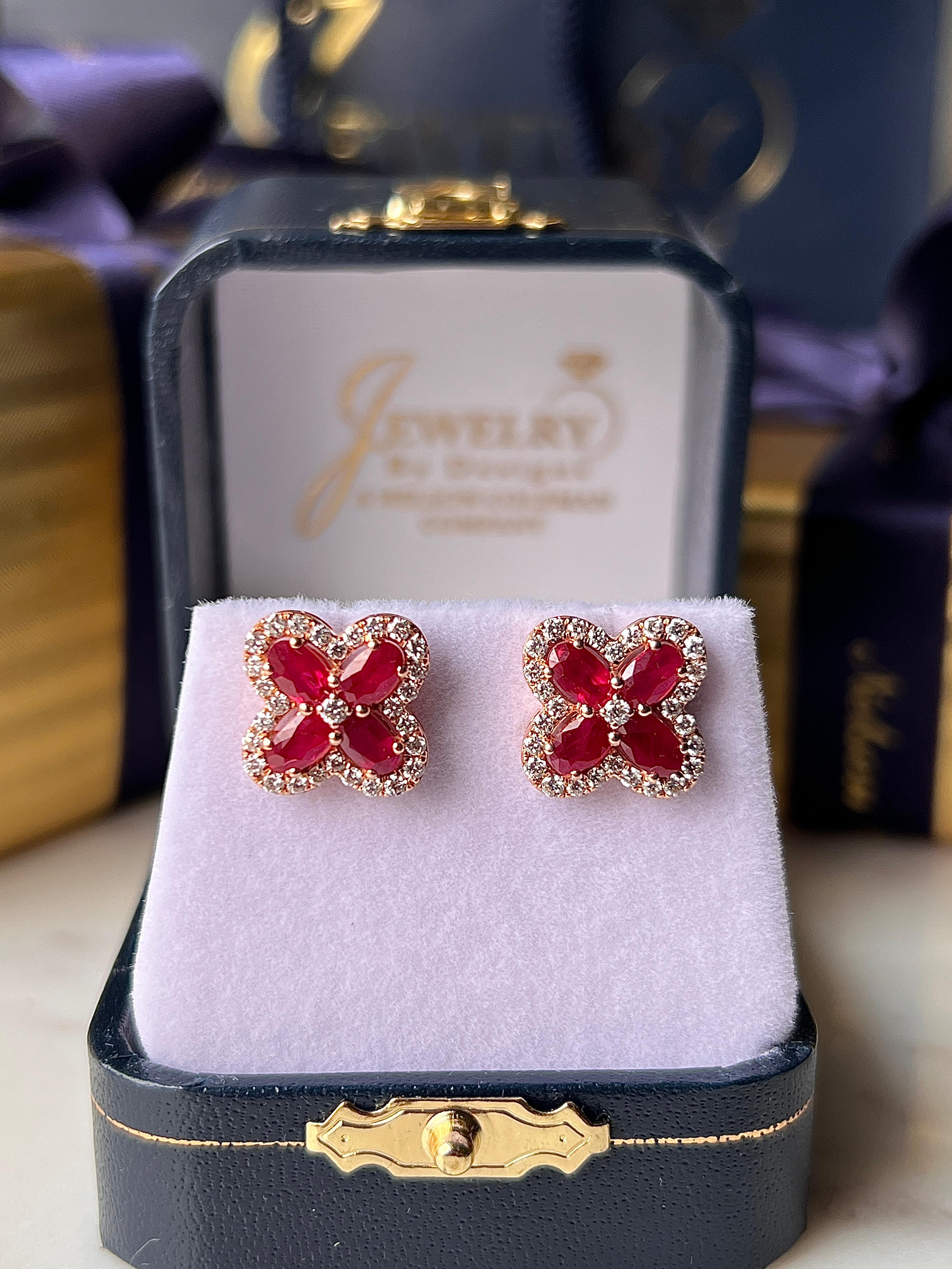 Un paio di orecchini contemporanei in oro rosa 14 carati con otto rubini dal taglio ovale per un peso totale di circa 2,32 carati. I vibranti rubini rossi sono disposti in un disegno a quadrifoglio di ispirazione floreale, accentuato da cinquantotto