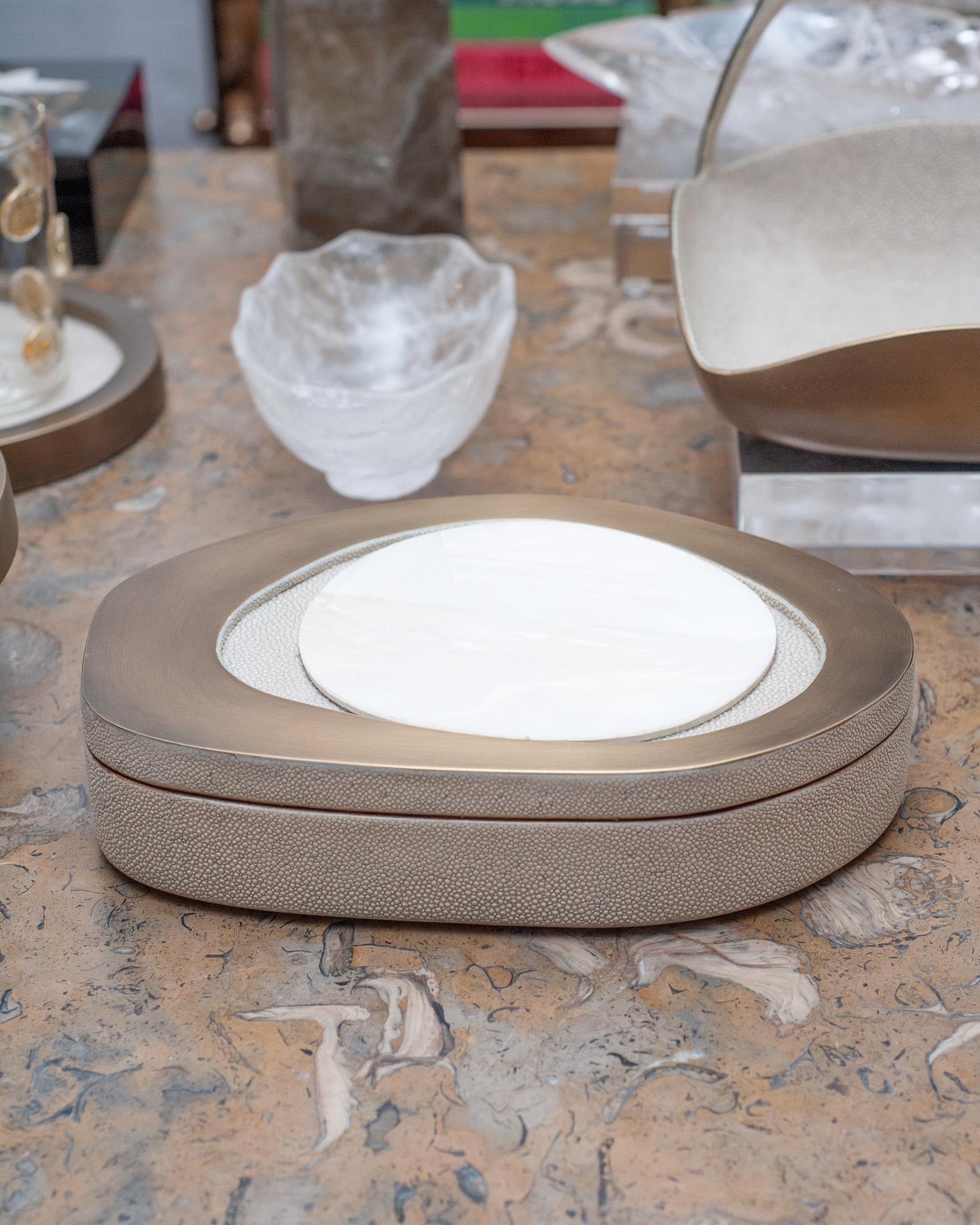 In stock now - A gorgeous decorative box in creme shagreen made R & Y Augousti, with brass inlay lid and white kabibi shell. Expertly crafted, this decorative box is a perfect accessory for any table and is as beautiful as it is functional. 