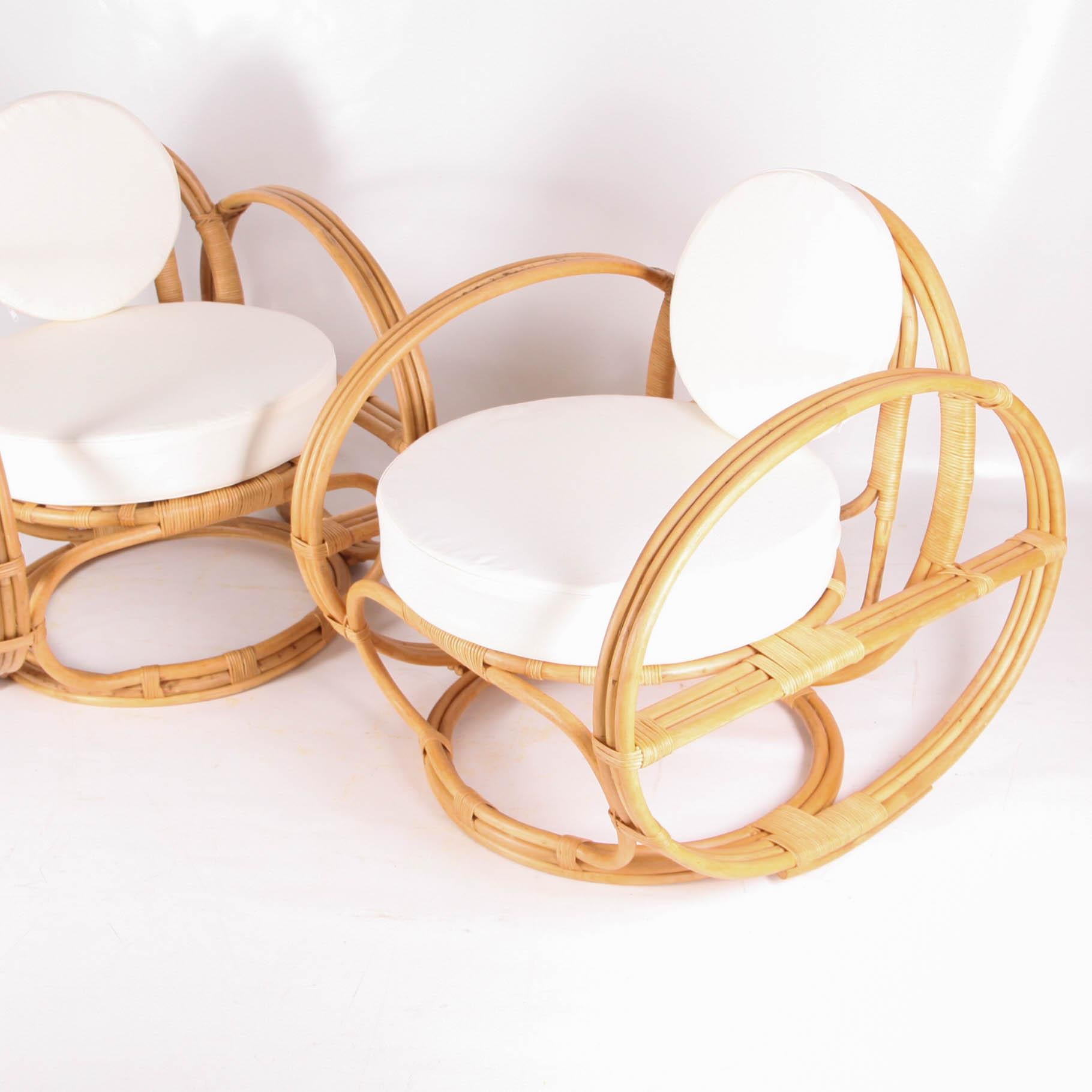 Beautiful elegant pair of rattan « hoops » armchairs. They are large, comfortable and high quality made. Entirely hand made, they are in excellent condition.