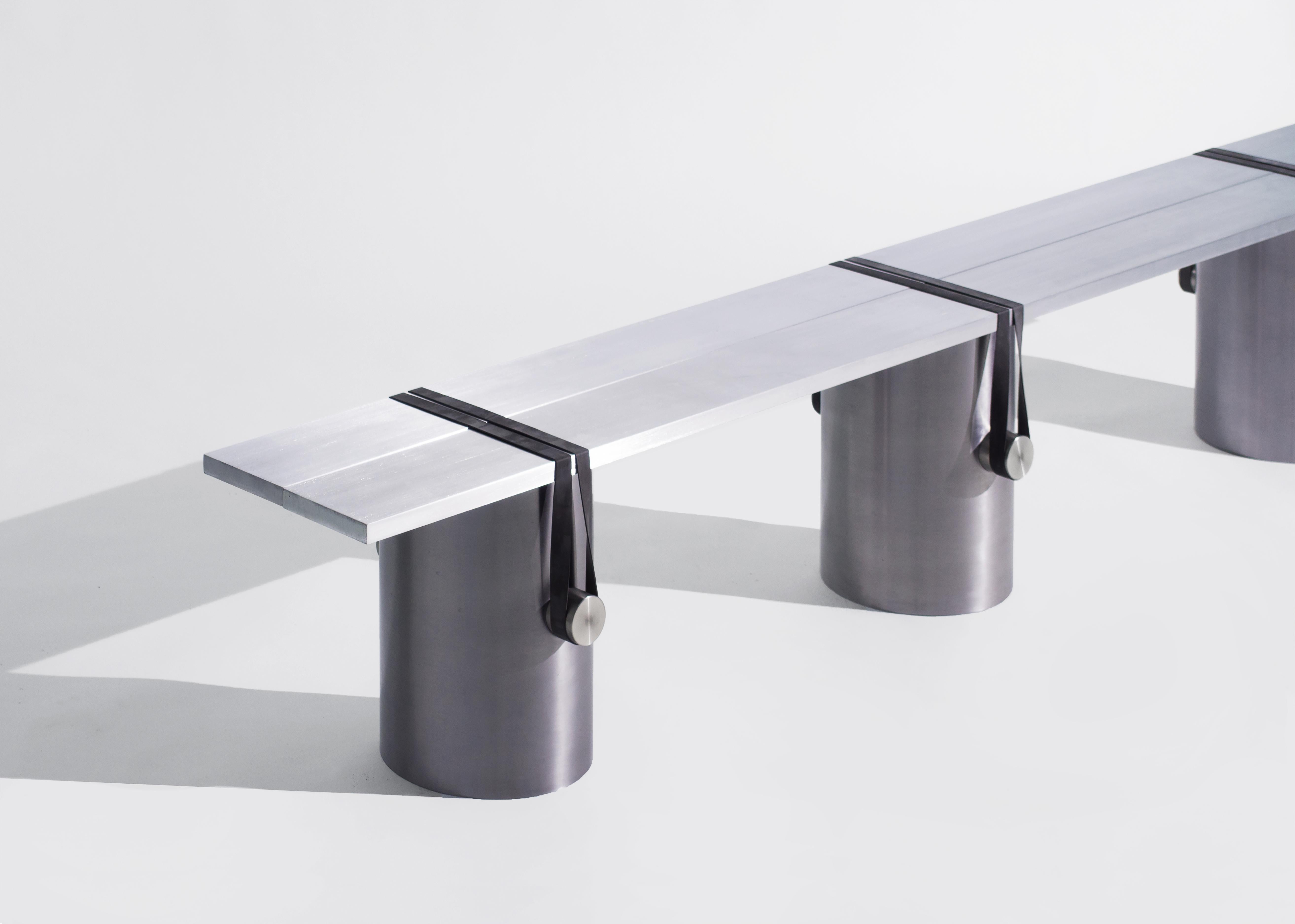 The RB02 bench is composed of two brushed aluminium plates leaning onto three lightly brushed steel tubes; held under tension with polished stainless steel cylinders and black rubber bands. 

This radical assemblage is the result of a continuous