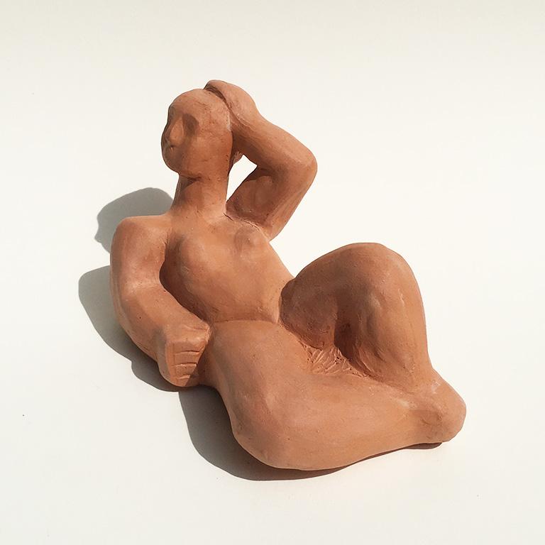 A reclining female figure in the manner of Henry Moore, unglazed terracotta, signed ERL on the bottom and dated 2019. Measures: 8