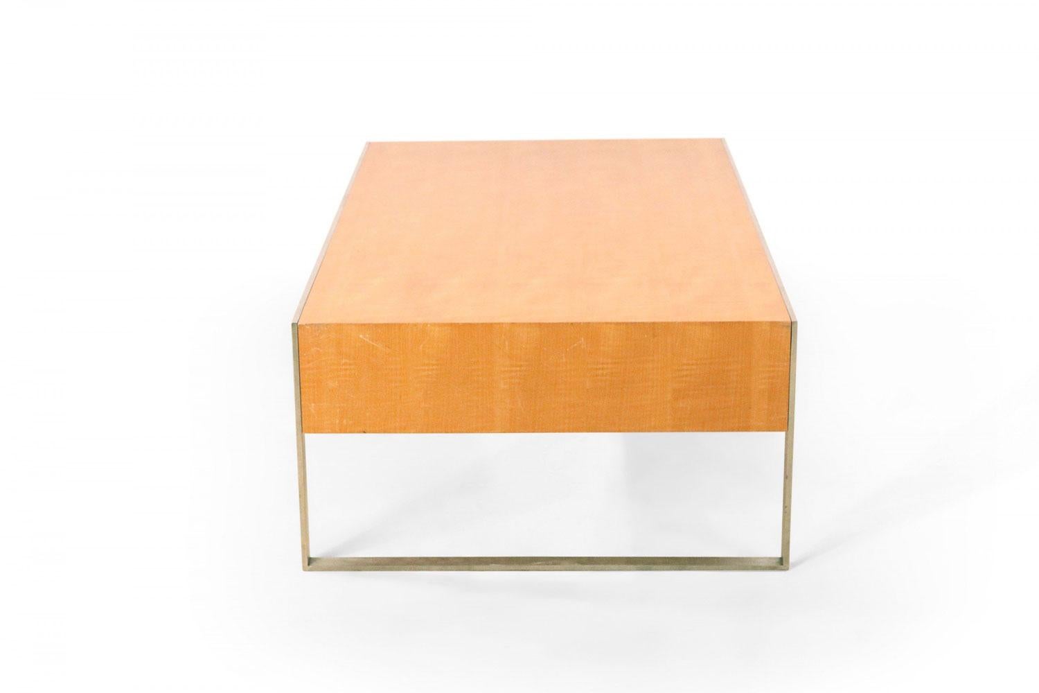 Table basse contemporaine rectangulaire avec plateau en érable et côtés courts sur une structure rectangulaire en acier.