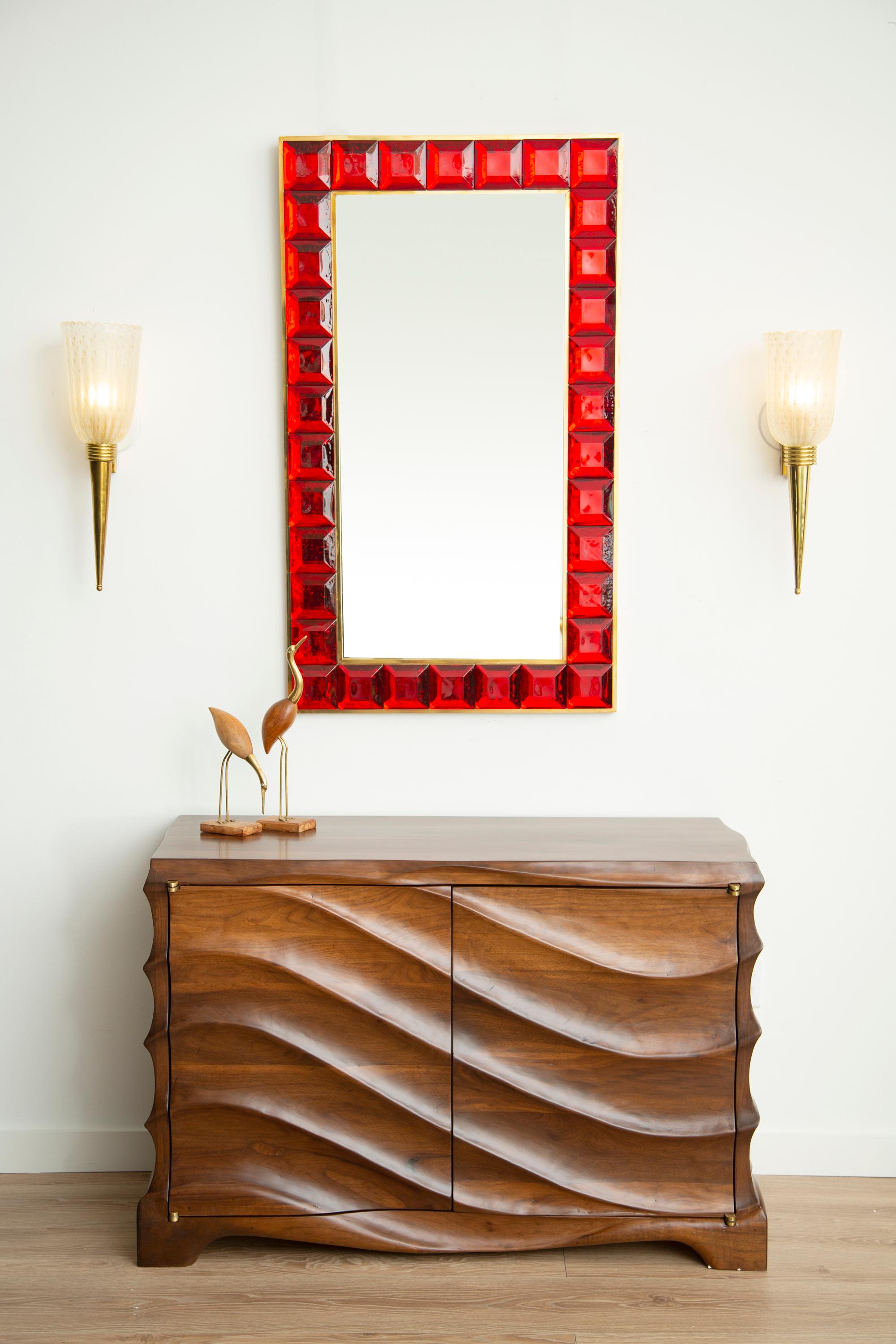 Contemporary ruby red square diamond cut Murano glass mirror (2 available), in stock
Vivid and intense ruby red glass block with naturally occurring air inclusions throughout 
 Highly polished faceted pattern
 Brass gallery
 Luxury handcrafted by a