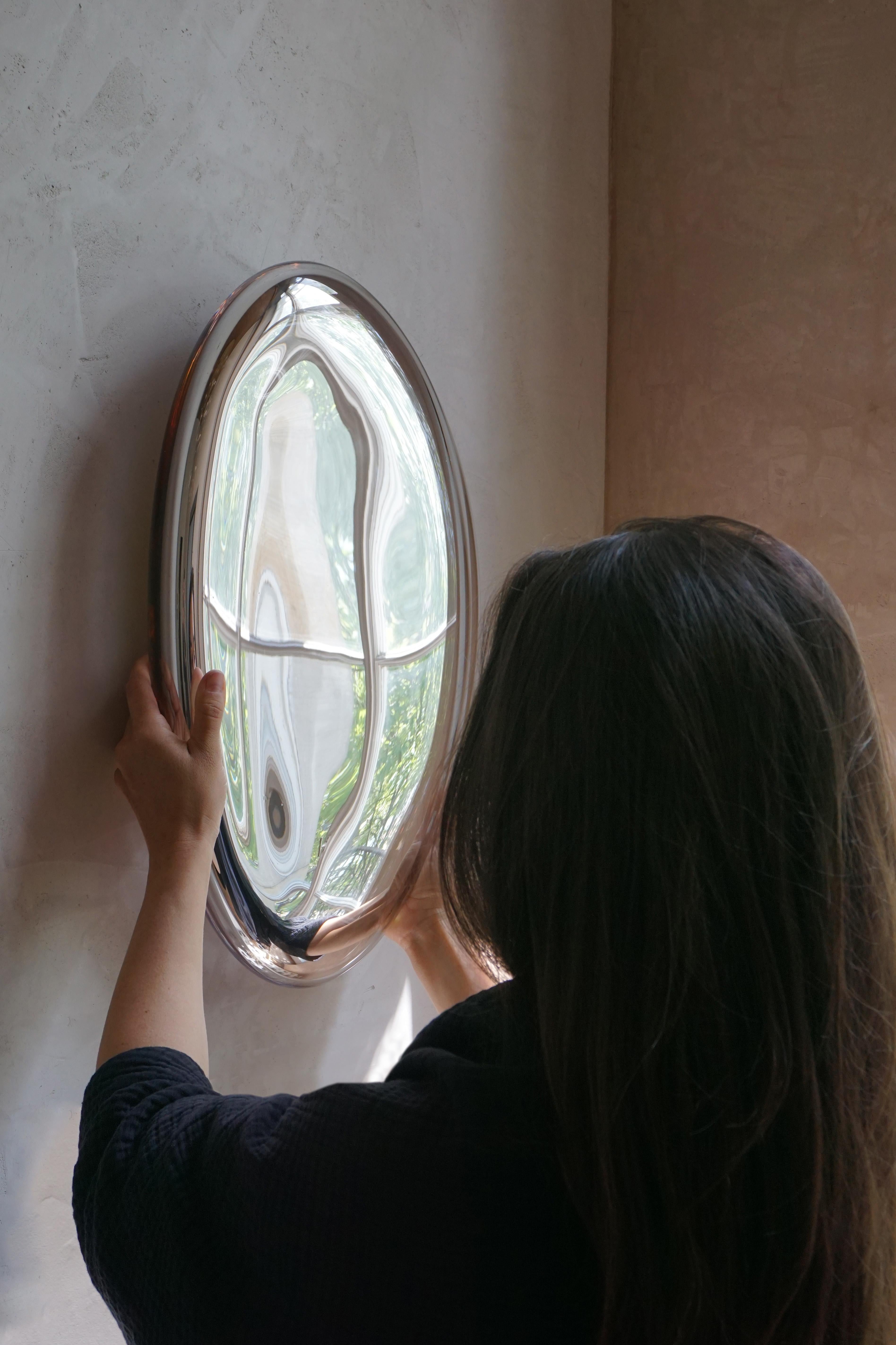 La série REFLECTION de sculptures tridimensionnelles en verre à effet miroir est soufflée à la bouche en volumes souples. Se reflétant tout autour, les sculptures fluides élargissent notre environnement. Transformant la matière solide en objets