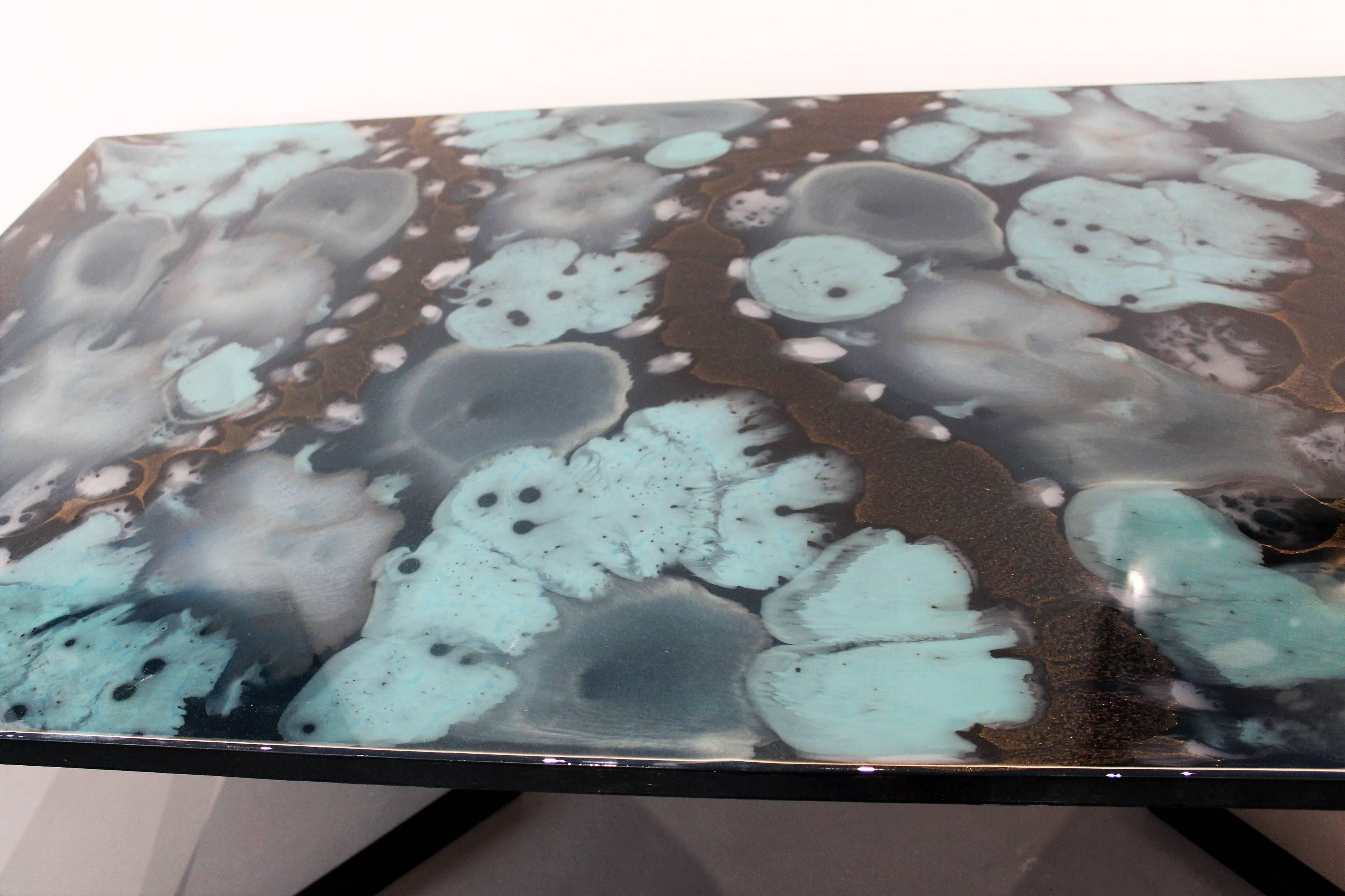 This unique dining table is part of Viscosity Art & Resin Gallery art furniture collection. The tabletop is made from handcrafted layers of colored resin to give these beautiful patterns. Inspired by nature, it reminds of the harmonious forms of