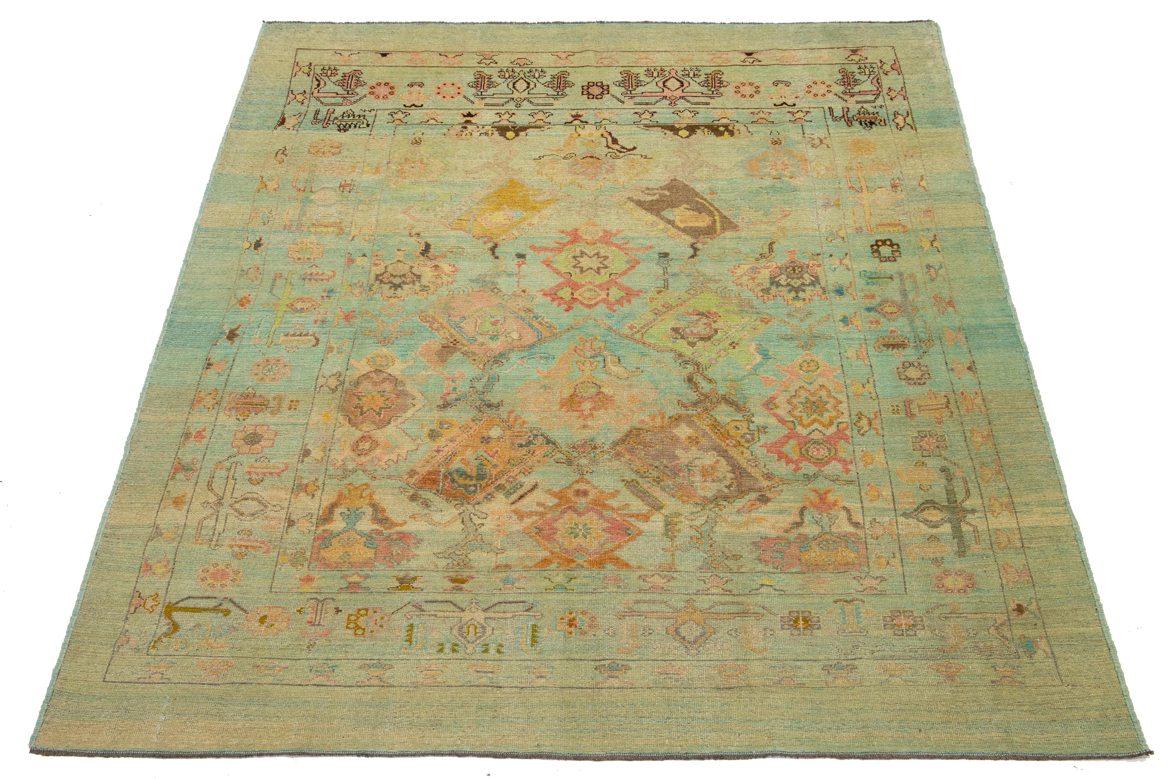 Gorgeous modern hand-knotted wool rug featuring a light blue and beige field. This Apadana Revival Collection rug showcases a stunning geometric, botanical floral design with peach, pink, brown, and teal accents.

This rug measures 7'7