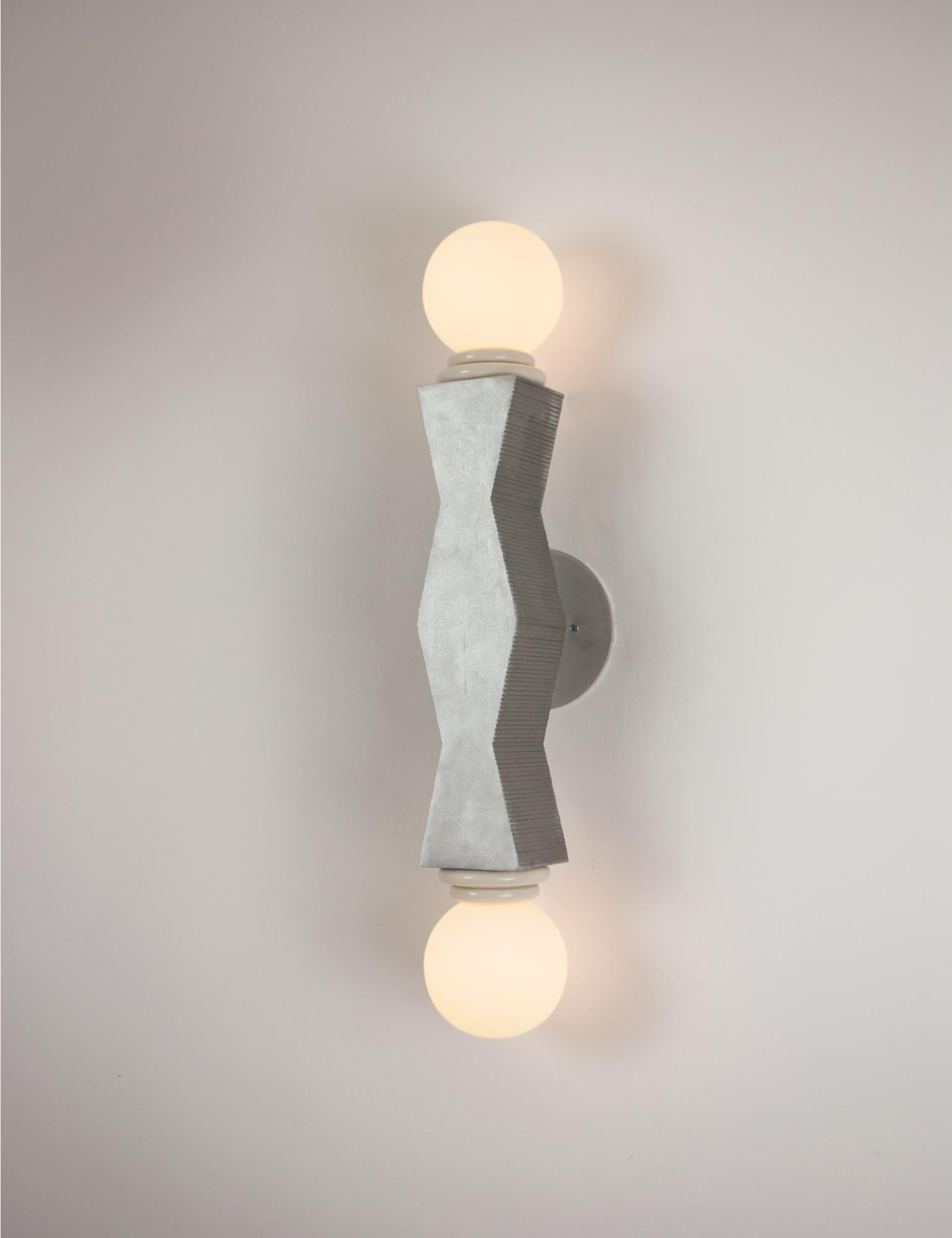 Contemporary Ridge wall light is hand-cast in aluminium with a raw brushed finish. The geometric cast form echo's early 20th century sculptors such as Brancusi and Noguchi. The ridged texture that gives the light its name is the result of the making